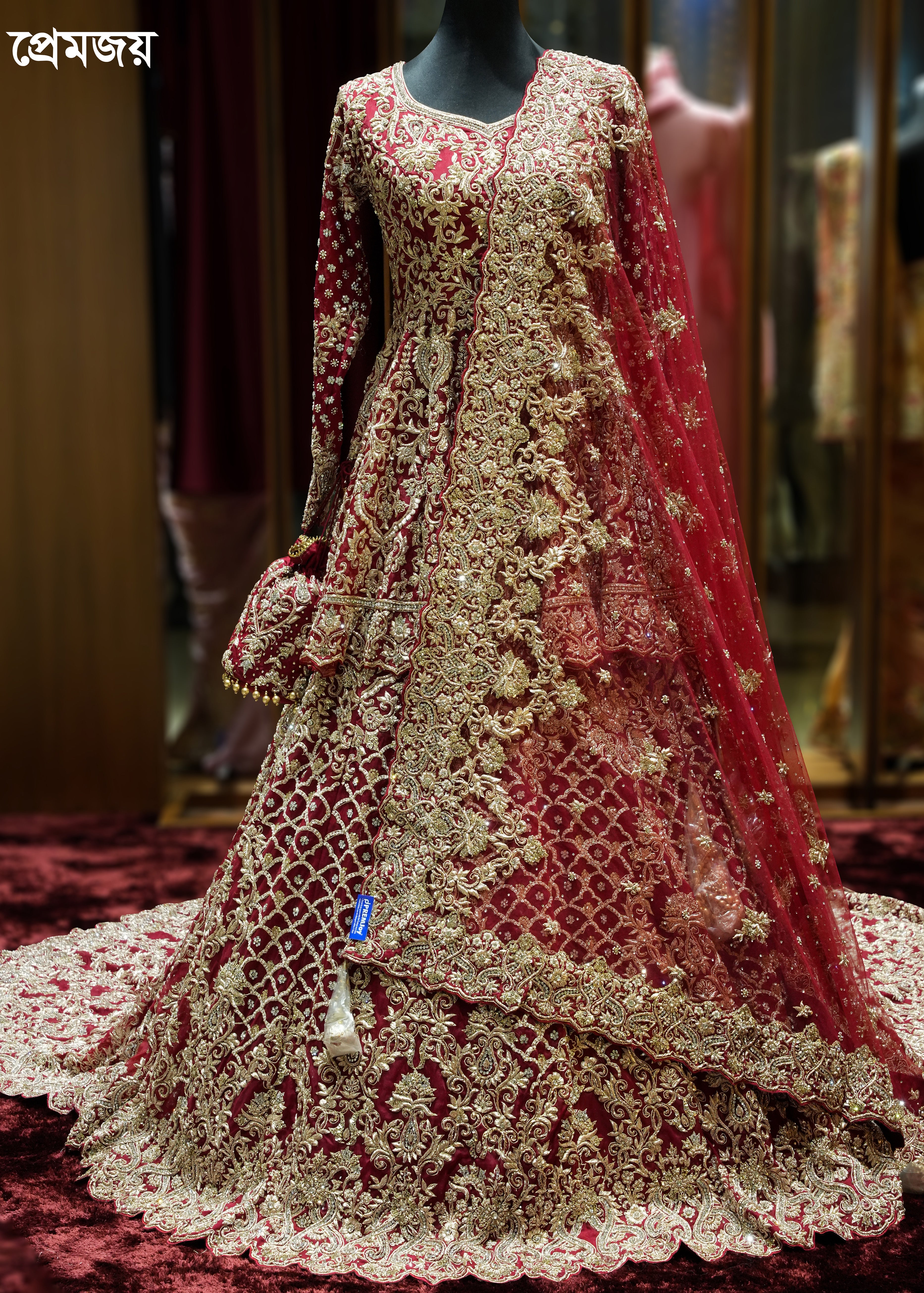 Elaborately embroidered red and gold traditional outfit on a mannequin.