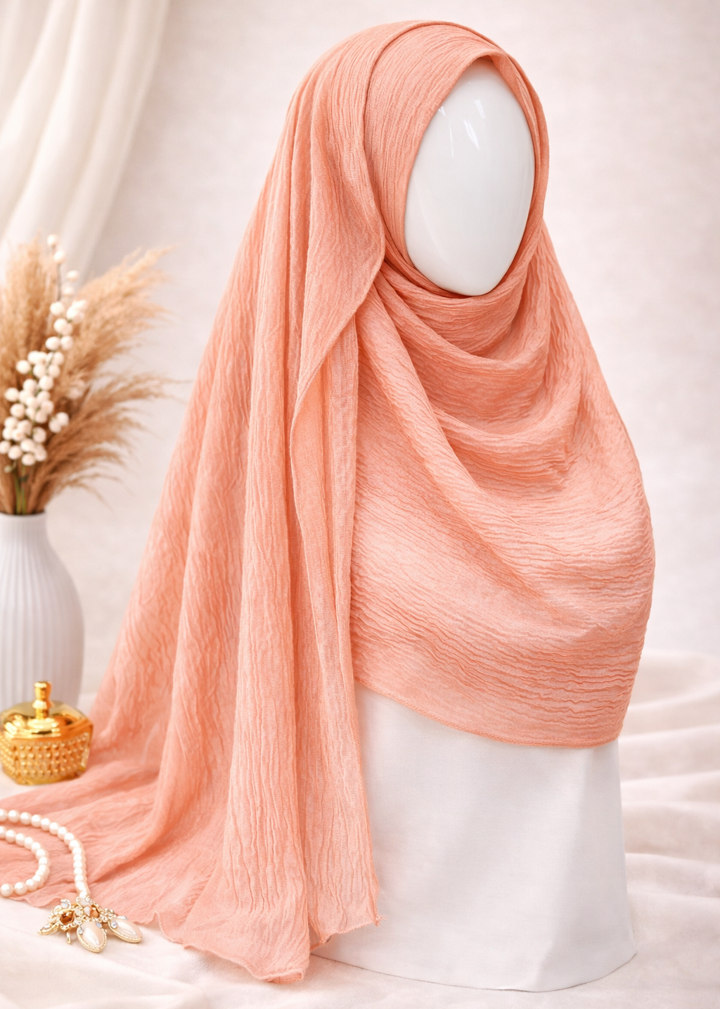 Peach hijab on a mannequin with decorative elements in the background