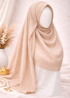 Beige hijab on a mannequin head with decorative elements on a light background