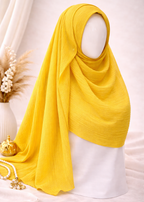 Yellow hijab on a mannequin against a white background