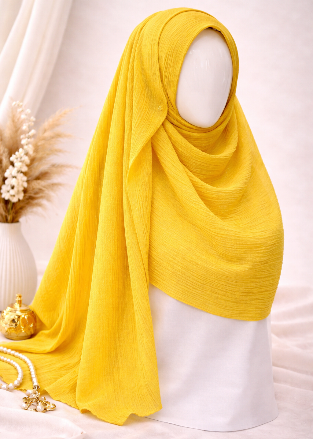 Yellow hijab on a mannequin against a white background