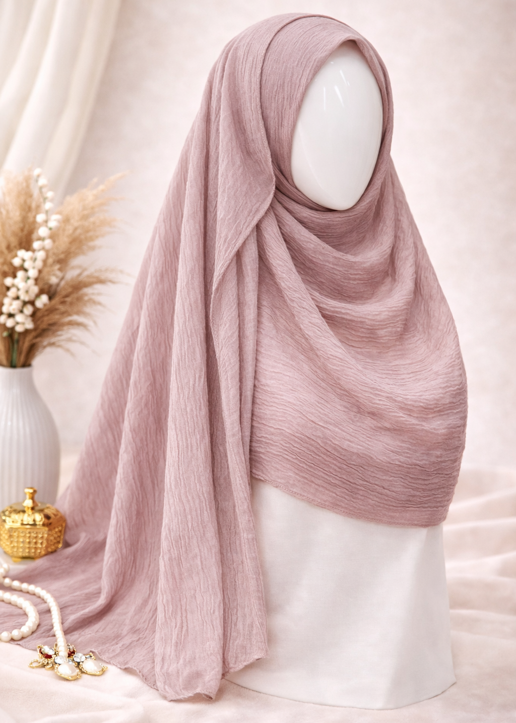 Pink hijab on a mannequin head against a soft pink background