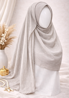 Light gray hijab on a mannequin head with decorative elements in the background