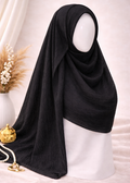 Black hijab on a mannequin head with decorative elements on a light background