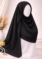 Black hijab on a mannequin head with decorative elements on a light background