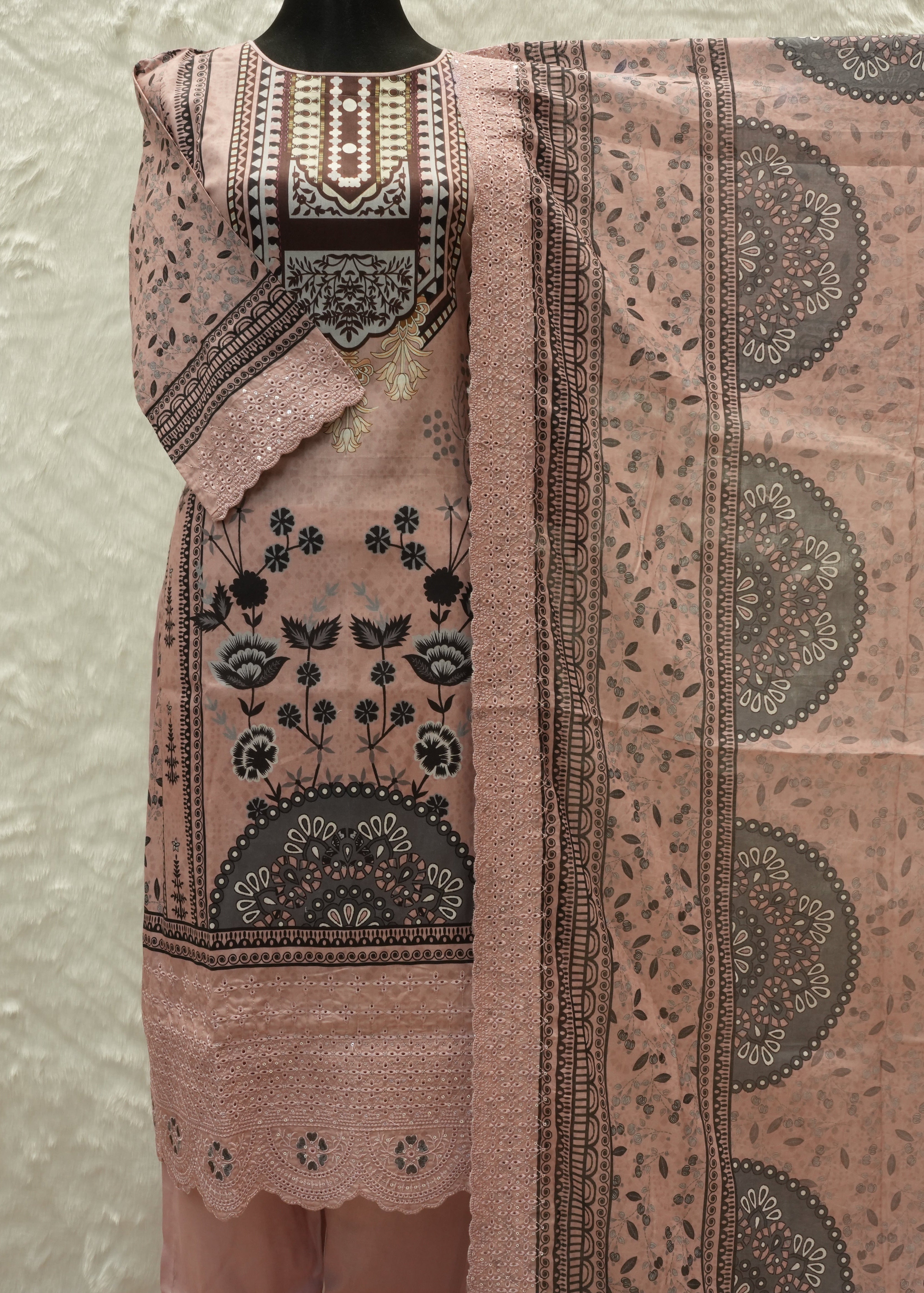 Pink traditional outfit with intricate patterns on a mannequin against a light background