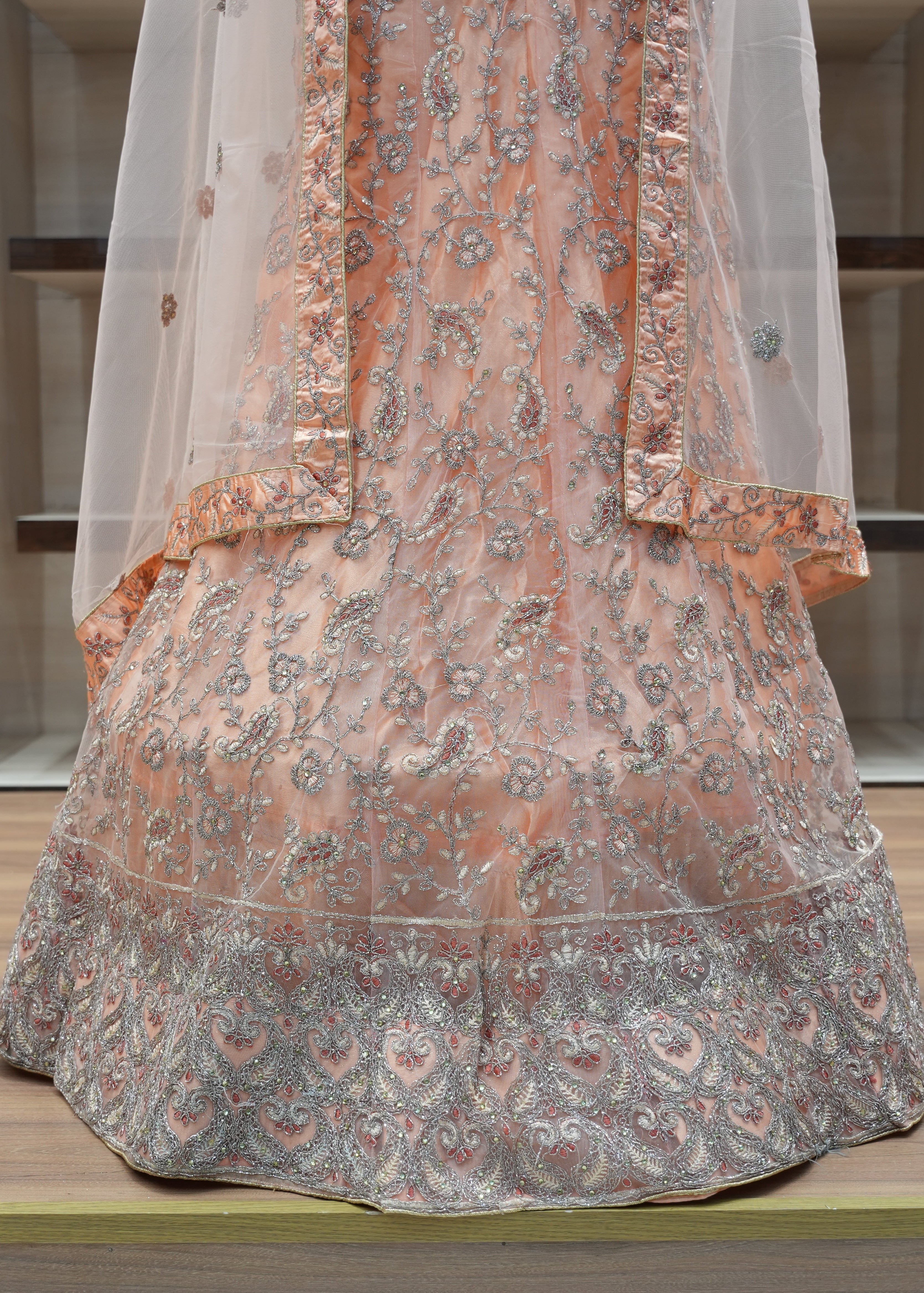 Traditional embroidered garment on a wooden platform with a neutral background
