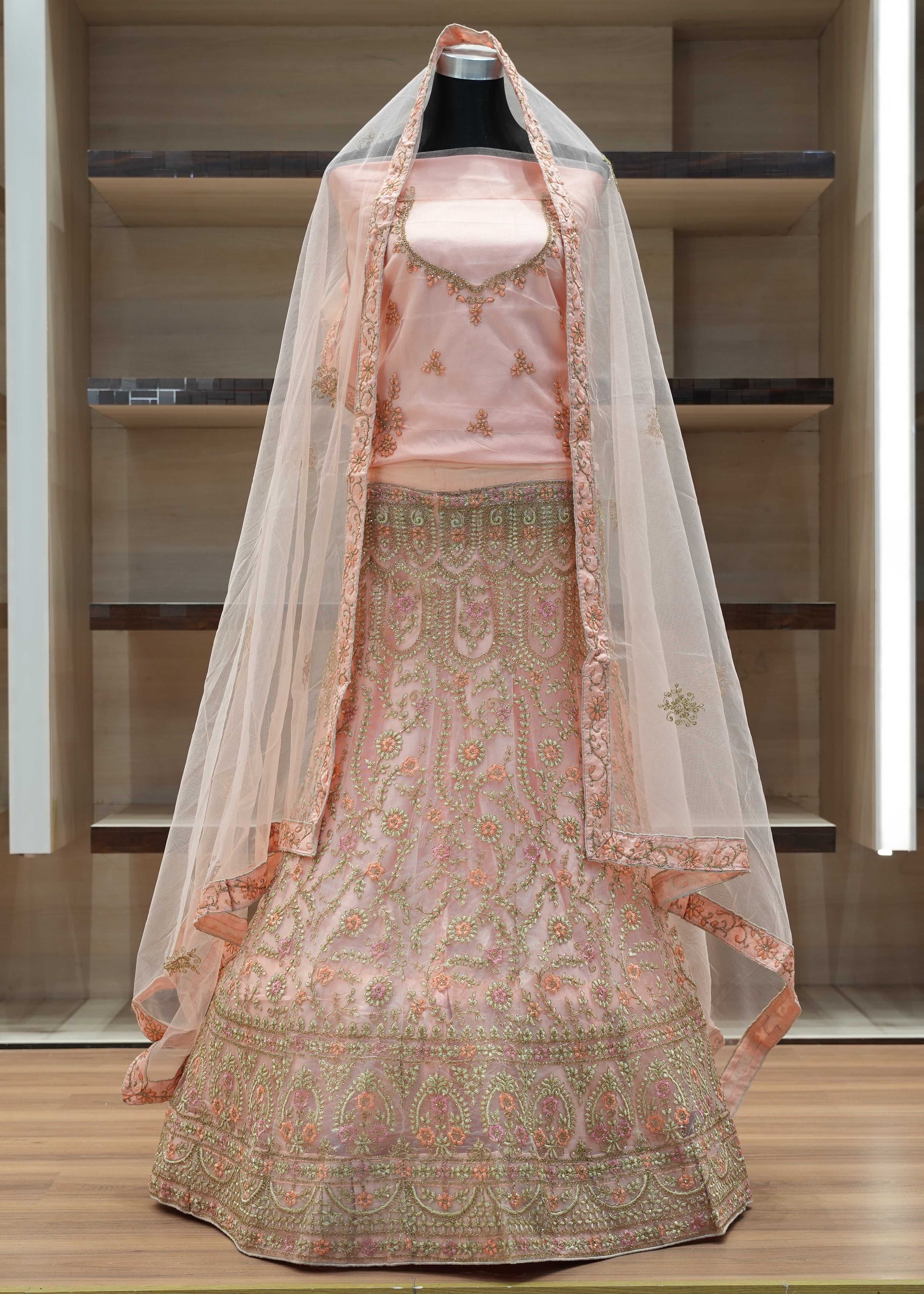 Traditional embroidered outfit with a dupatta on a mannequin against a neutral background