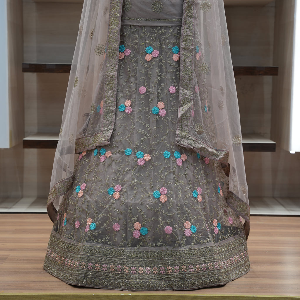 Traditional embroidered outfit with a sheer dupatta on a wooden surface