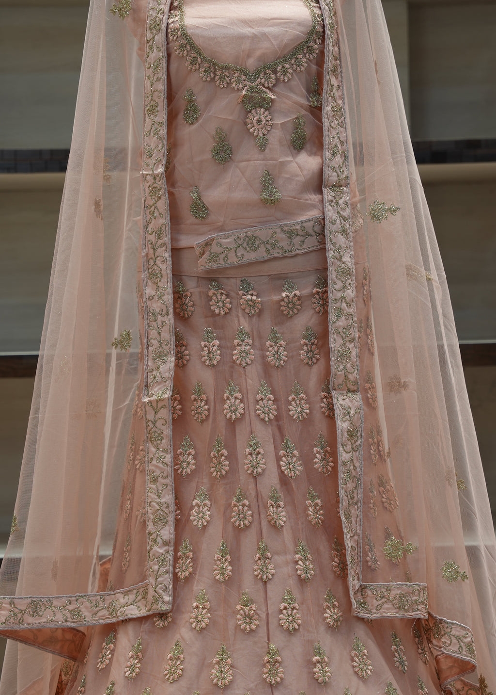 Pink embroidered traditional outfit with a sheer dupatta on a neutral background