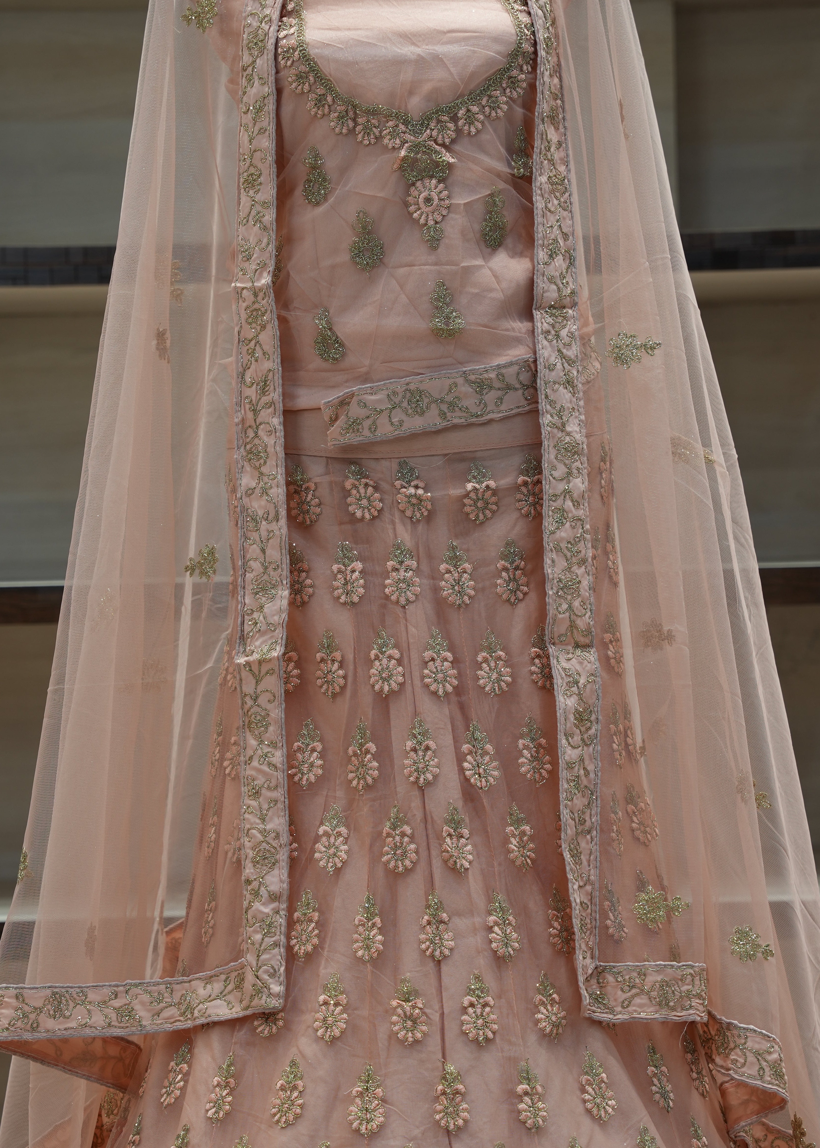 Pink embroidered traditional outfit with a sheer dupatta on a neutral background