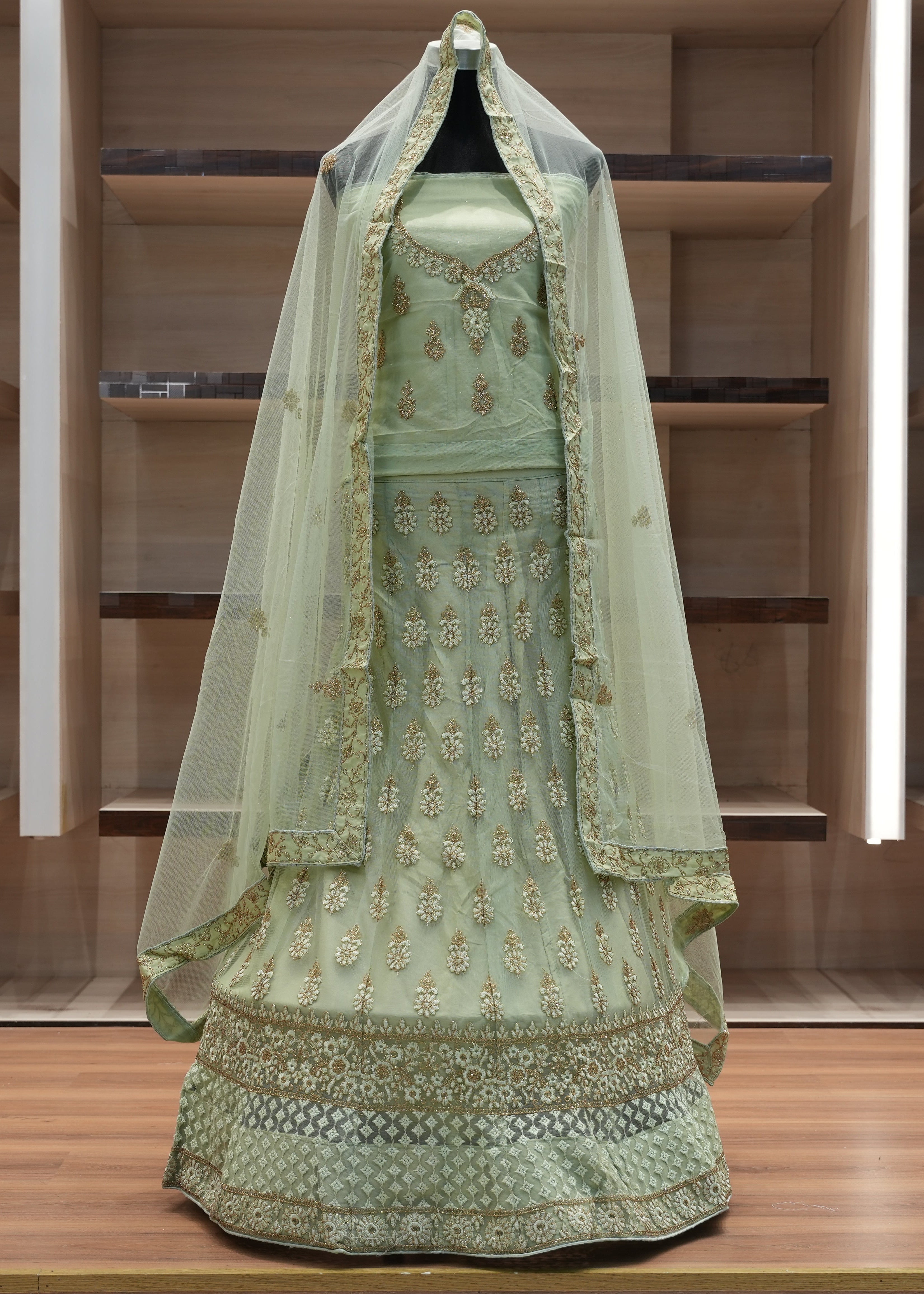 Green embroidered traditional outfit with a veil on a wooden platform