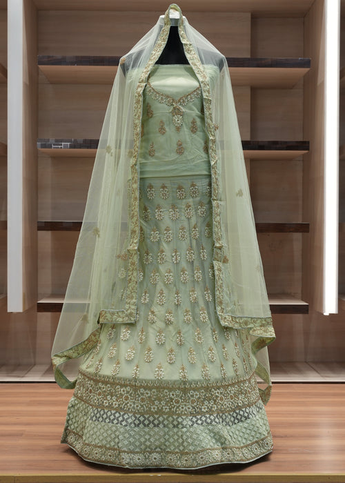 Green embroidered traditional outfit with a veil on a wooden platform