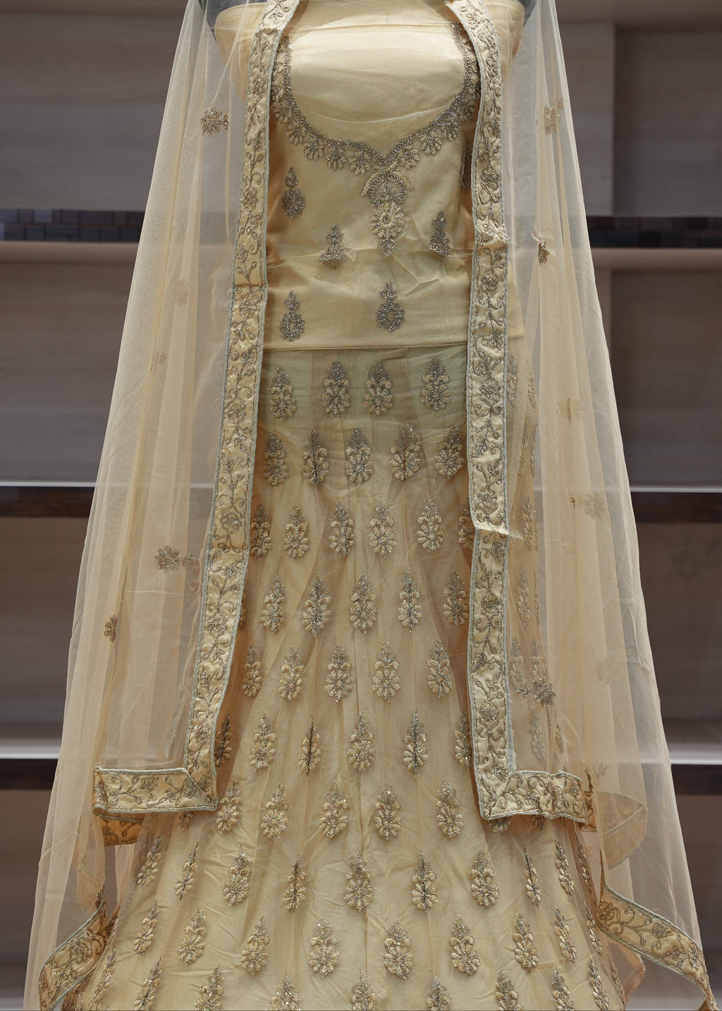 Beige embroidered traditional outfit with a dupatta on a neutral background
