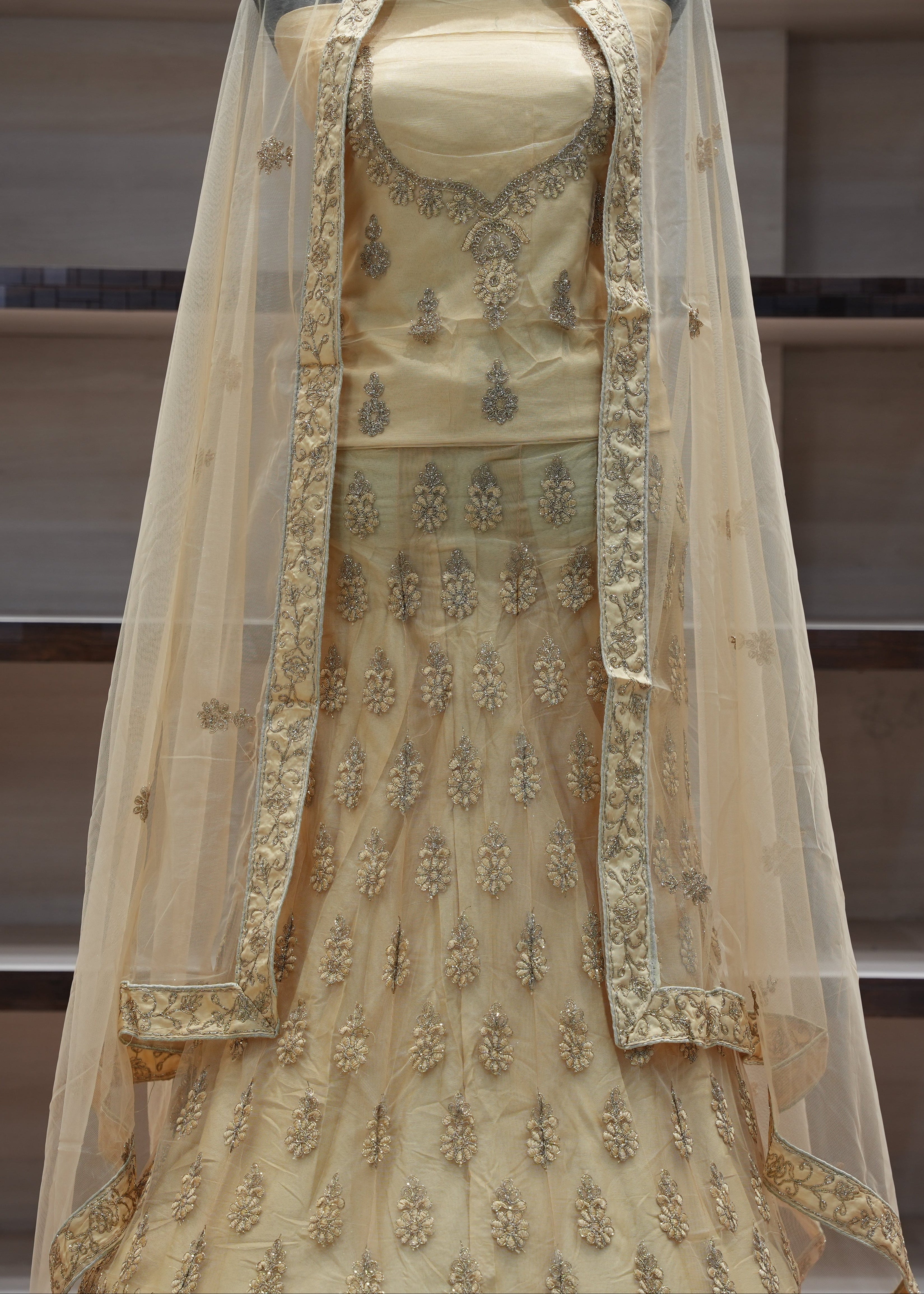 Beige embroidered traditional outfit with a dupatta on a neutral background