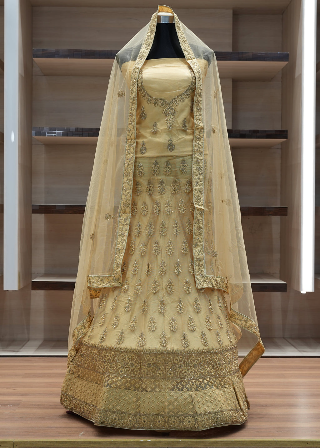Traditional embroidered dress with a dupatta on a mannequin against a neutral background