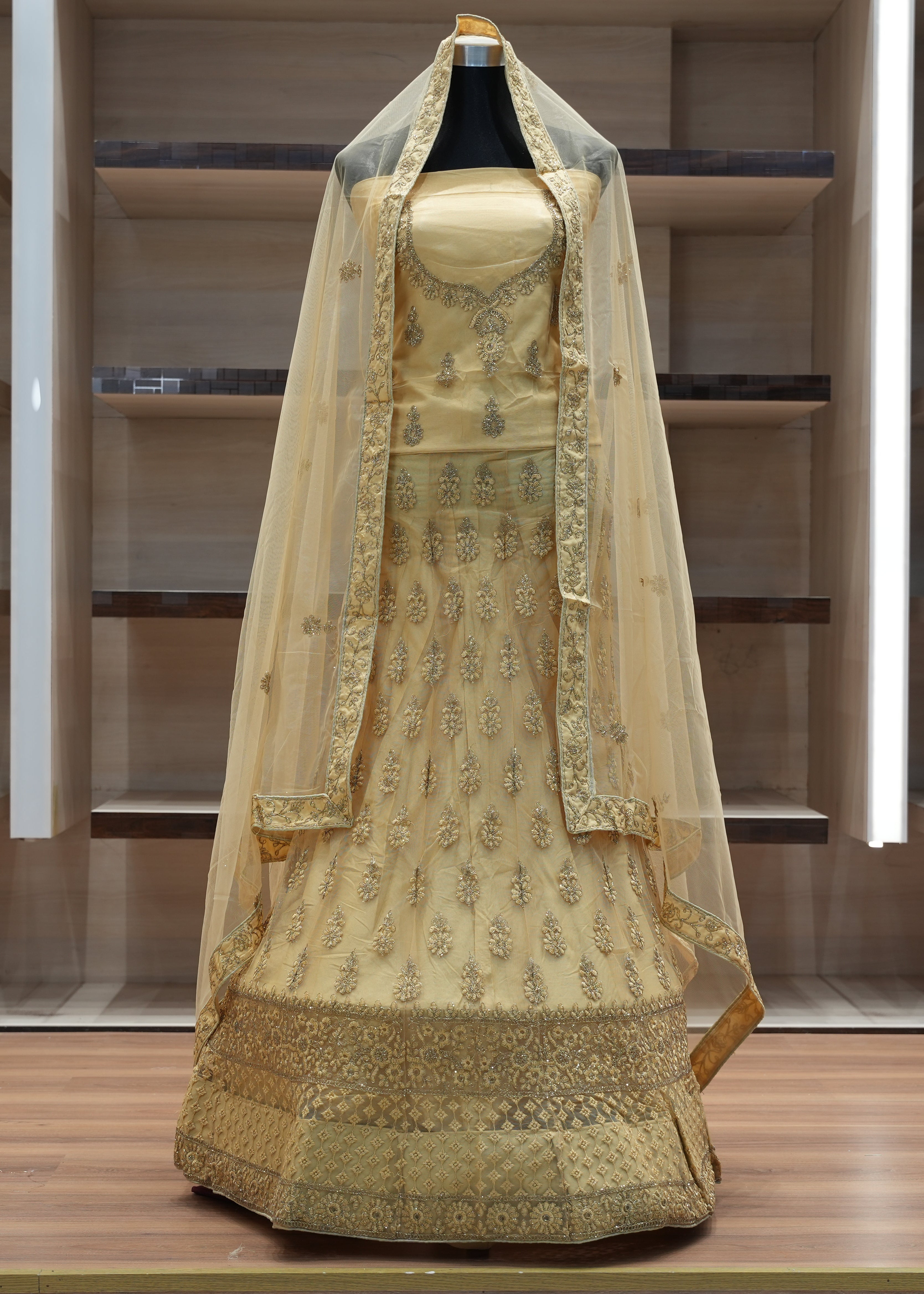 Traditional embroidered dress with a dupatta on a mannequin against a neutral background