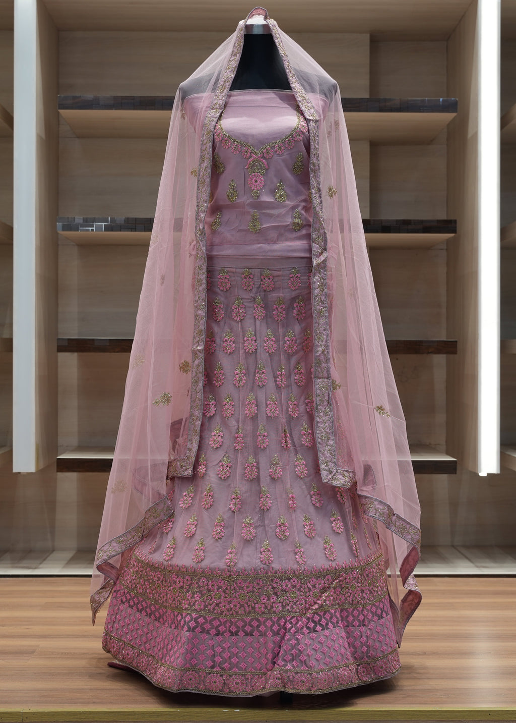 Pink embroidered traditional outfit with a dupatta on a wooden platform