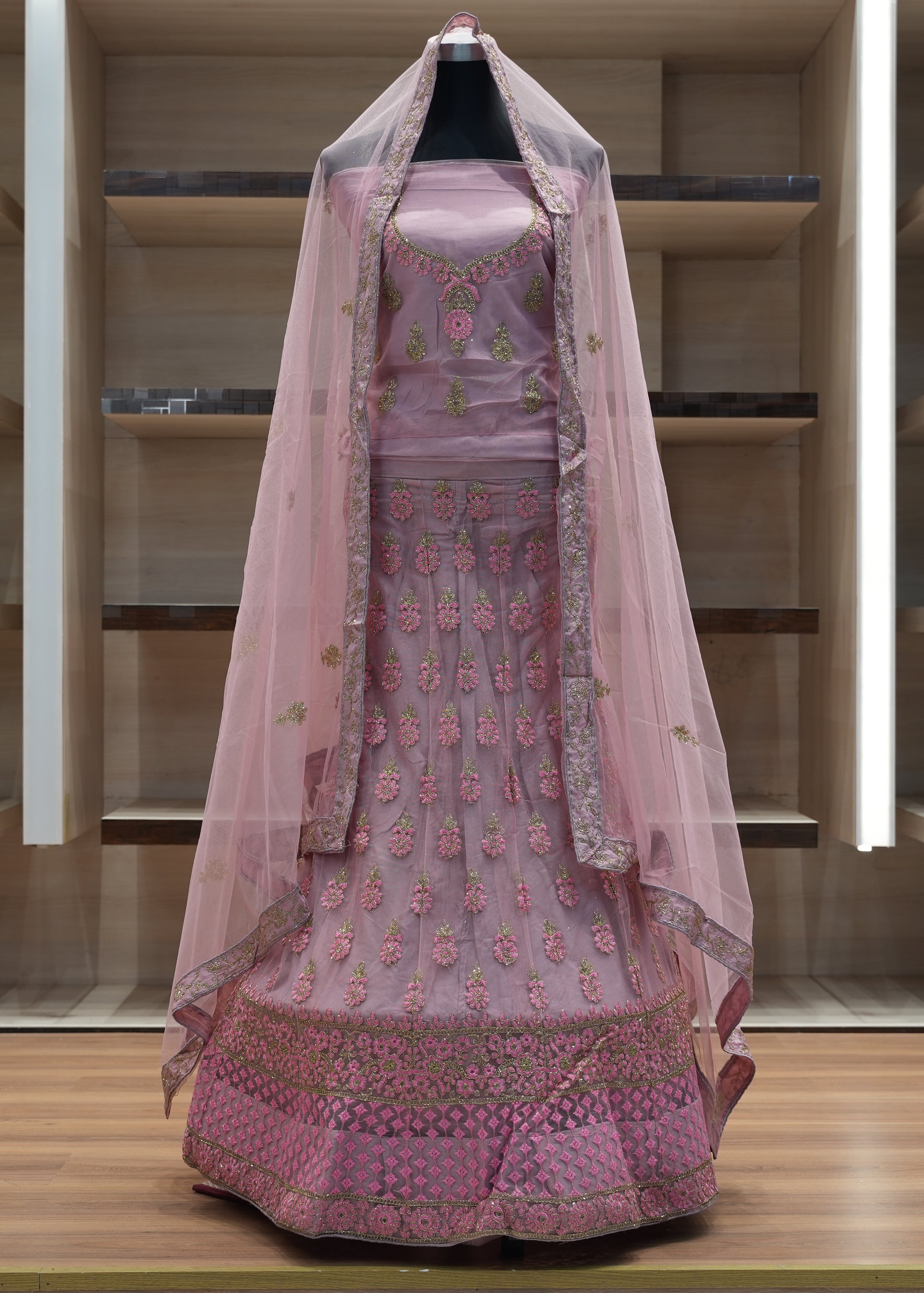 Pink embroidered traditional outfit with a dupatta on a wooden platform