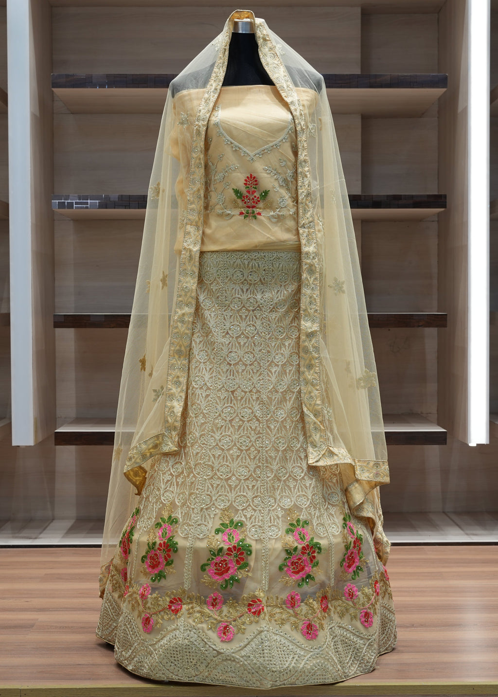 Traditional embroidered dress with a veil on a mannequin against a neutral background
