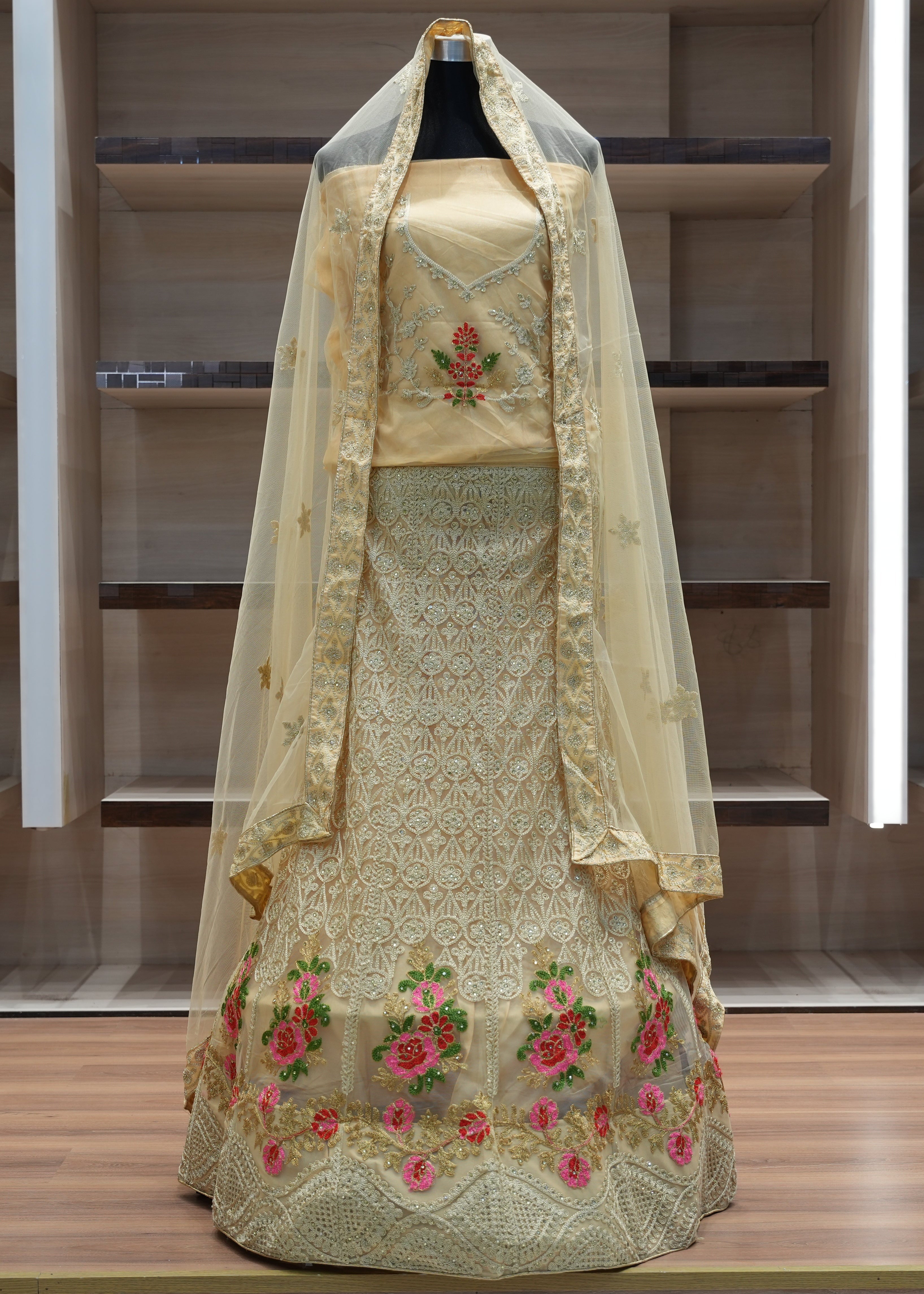 Traditional embroidered dress with a veil on a mannequin against a neutral background