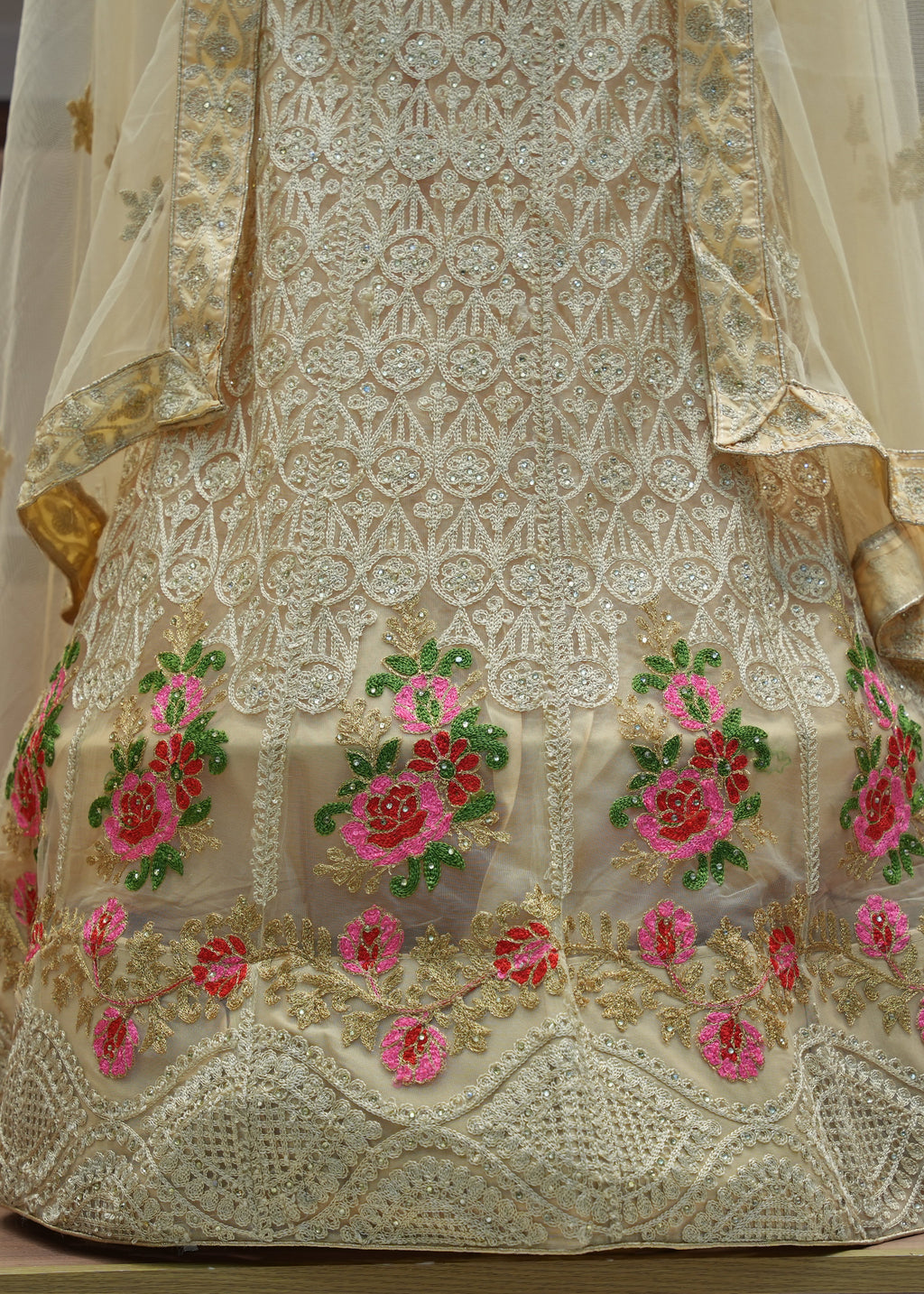 Embroidered saree with floral patterns on a wooden surface