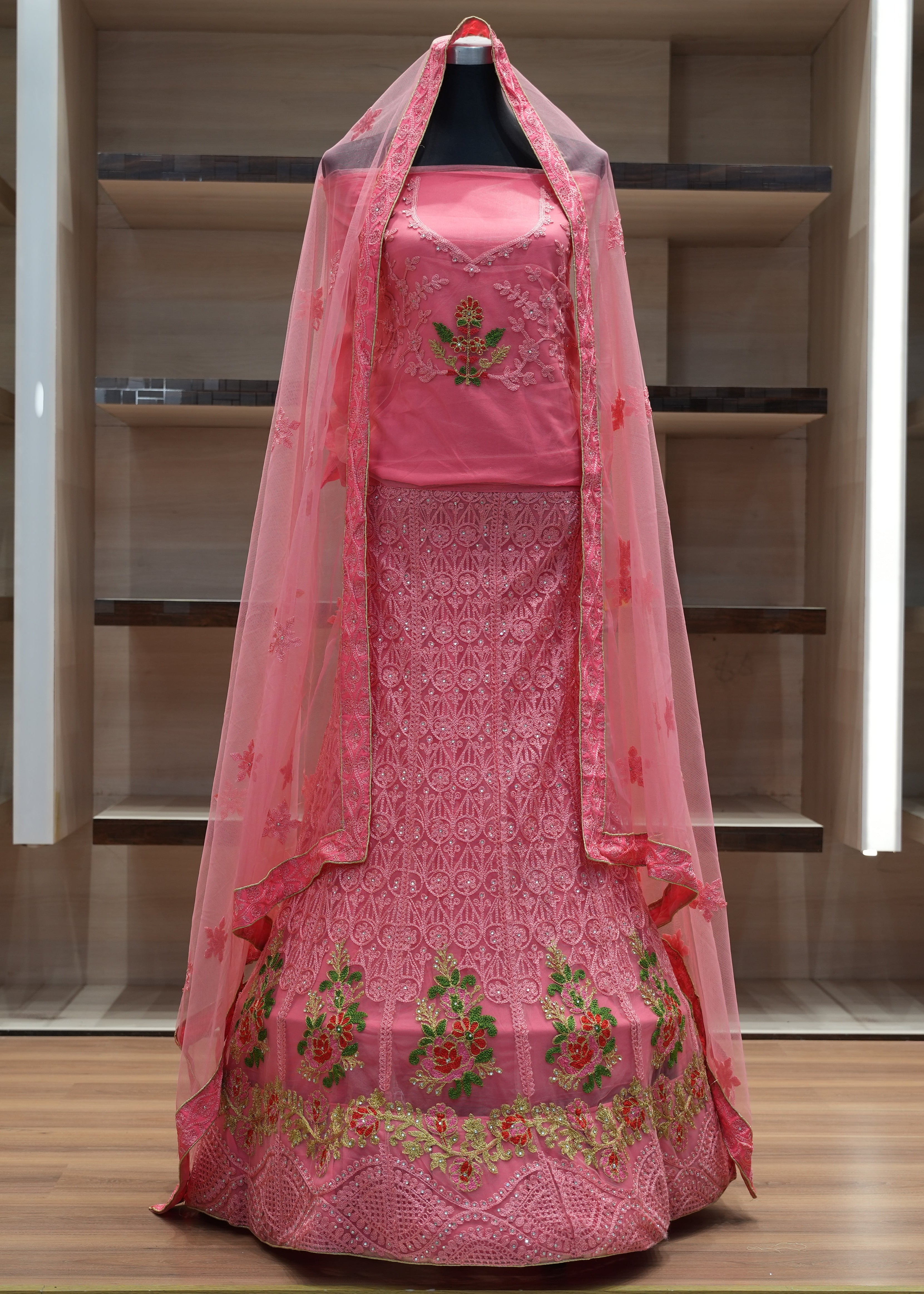 Pink embroidered traditional outfit with a dupatta on a mannequin against a neutral background