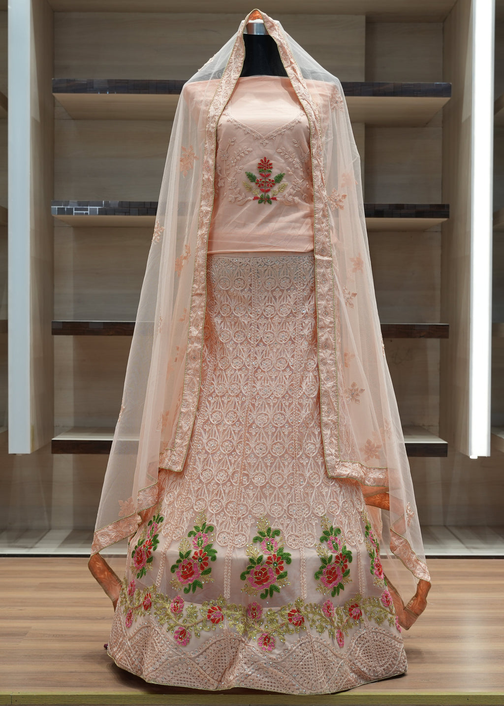 Traditional embroidered dress with a dupatta on a mannequin against a minimalistic background