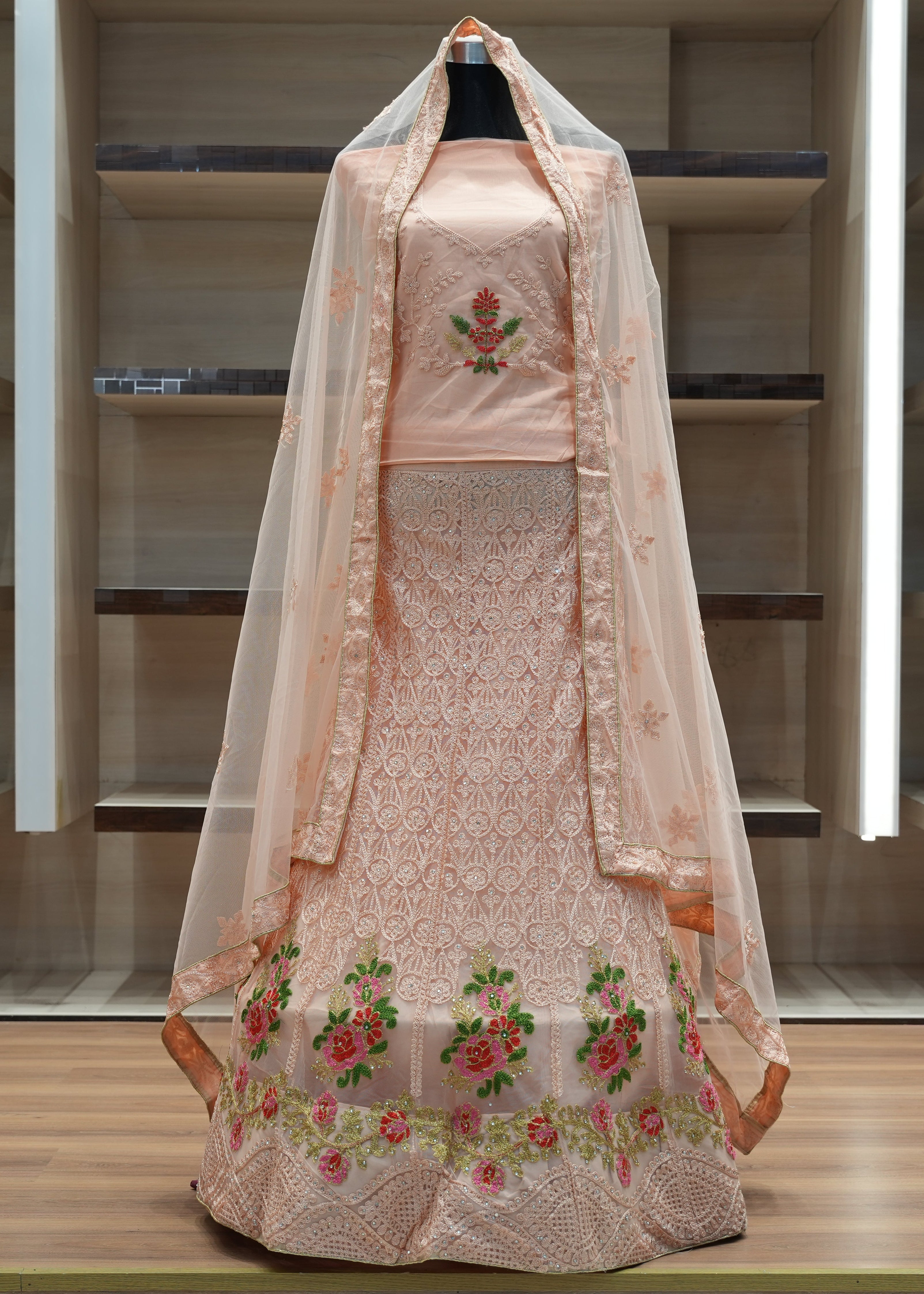 Traditional embroidered dress with a dupatta on a mannequin against a minimalistic background