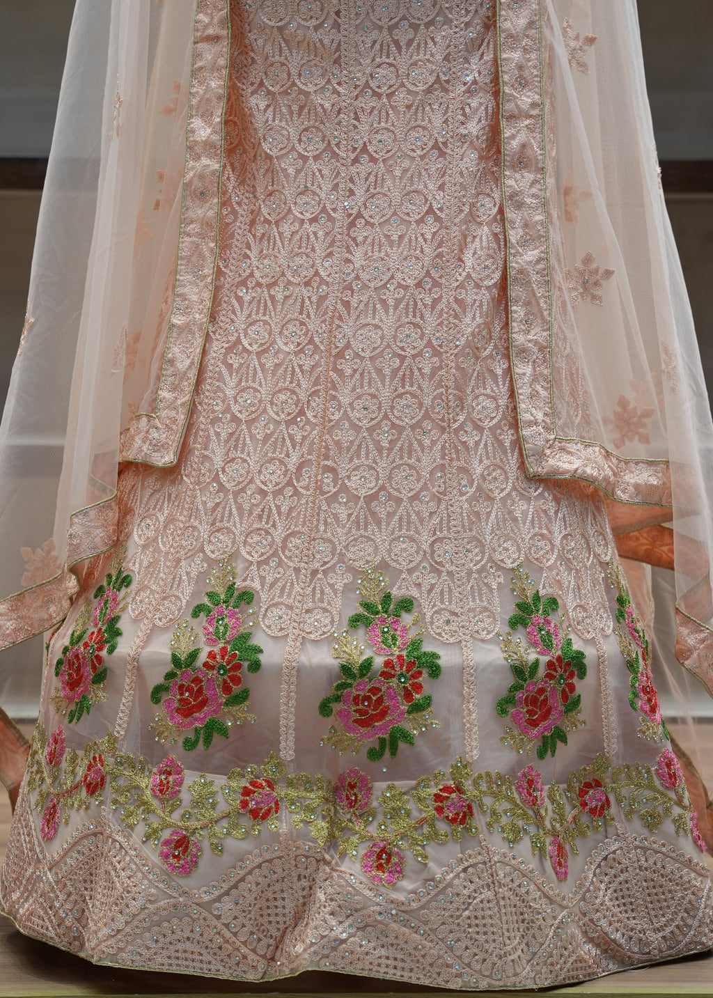 Embroidered traditional outfit with floral patterns on a neutral background
