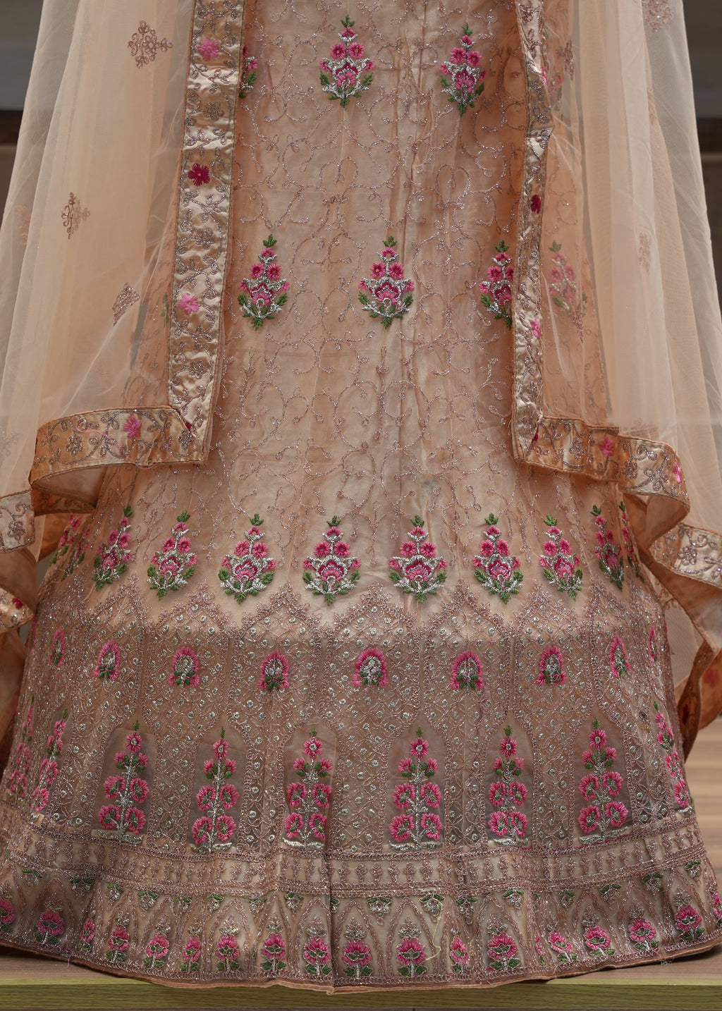 Traditional embroidered garment with floral patterns on a neutral background