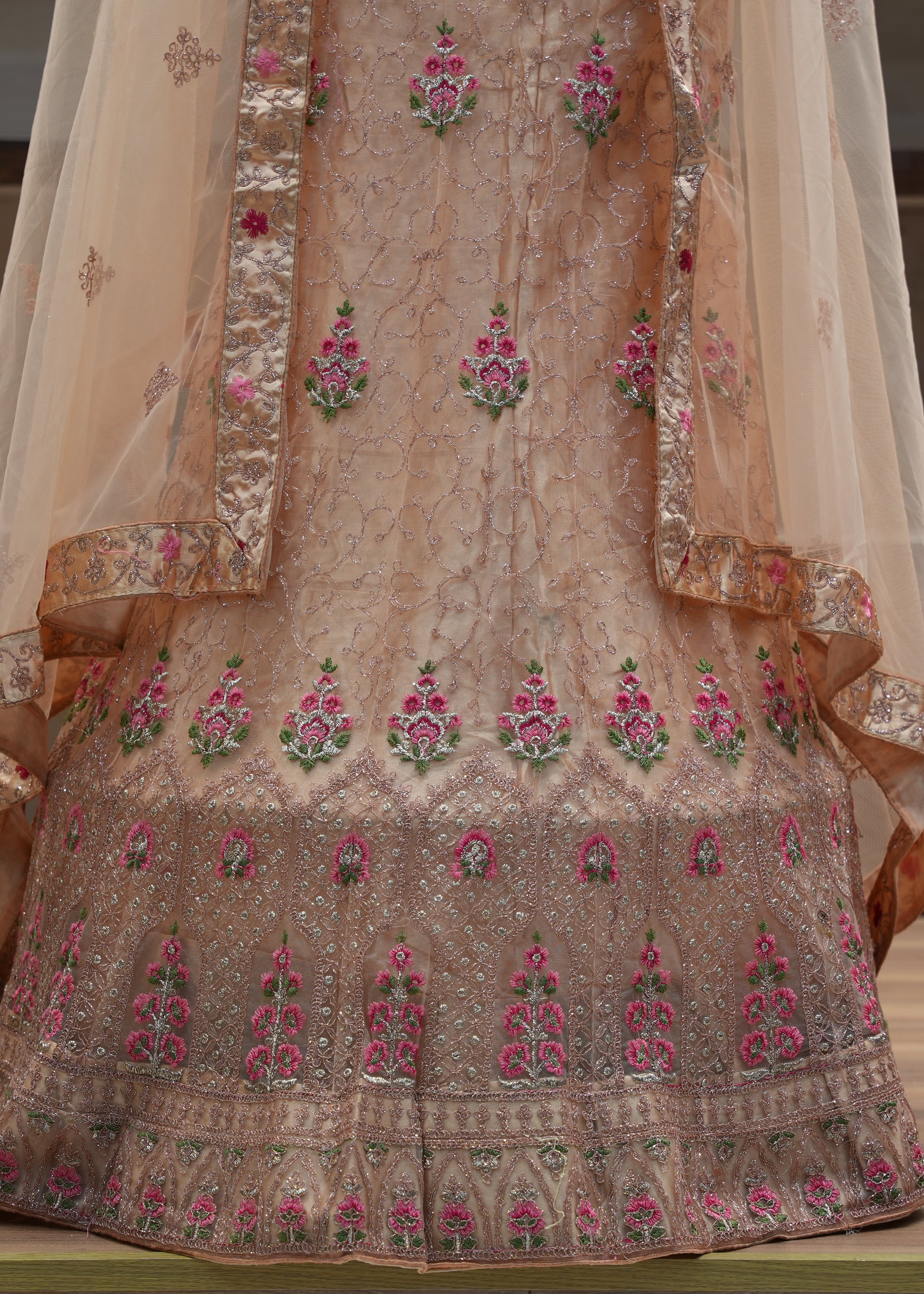 Traditional embroidered garment with floral patterns on a neutral background