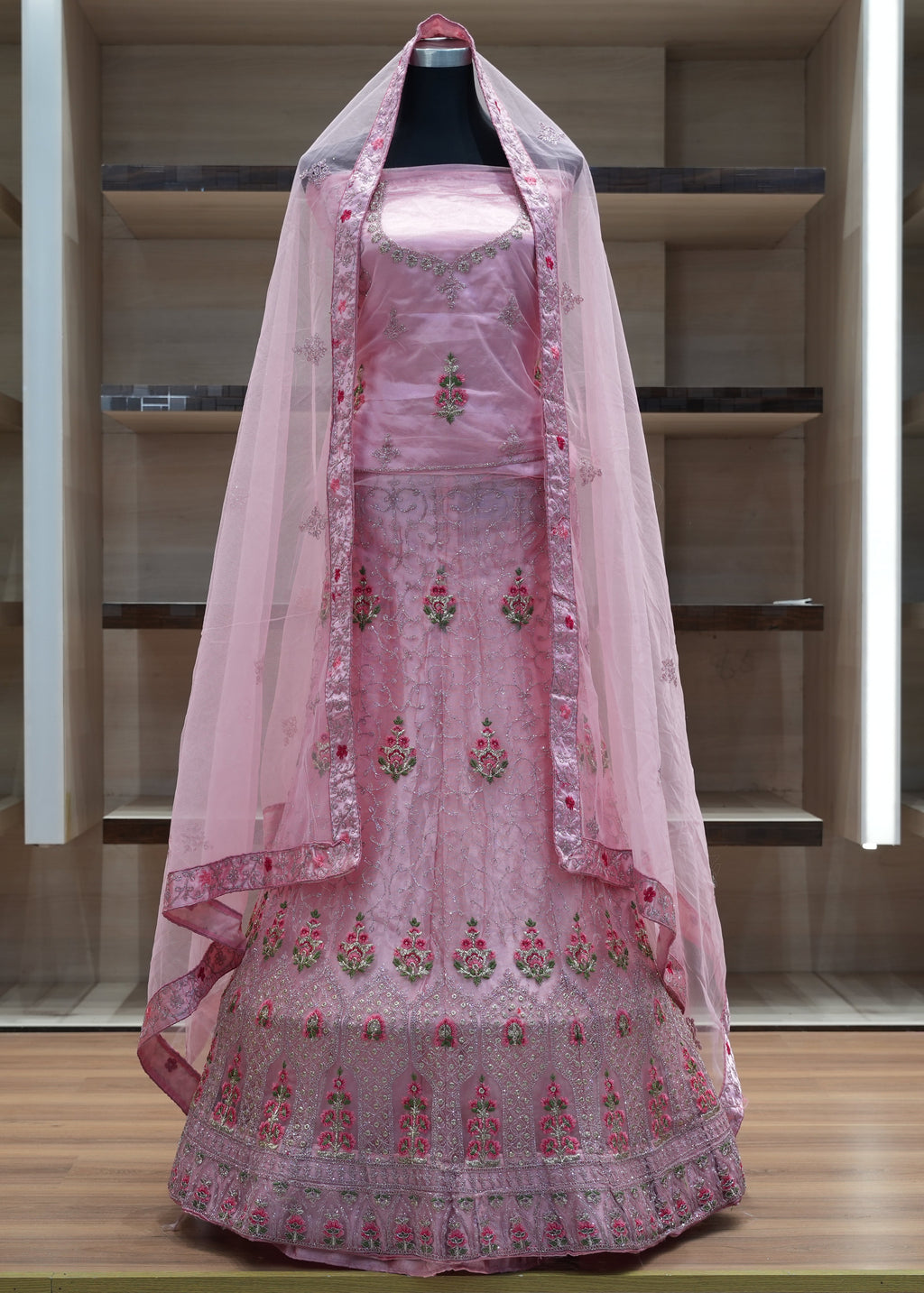 Pink embroidered traditional outfit with a dupatta on a mannequin against a neutral background