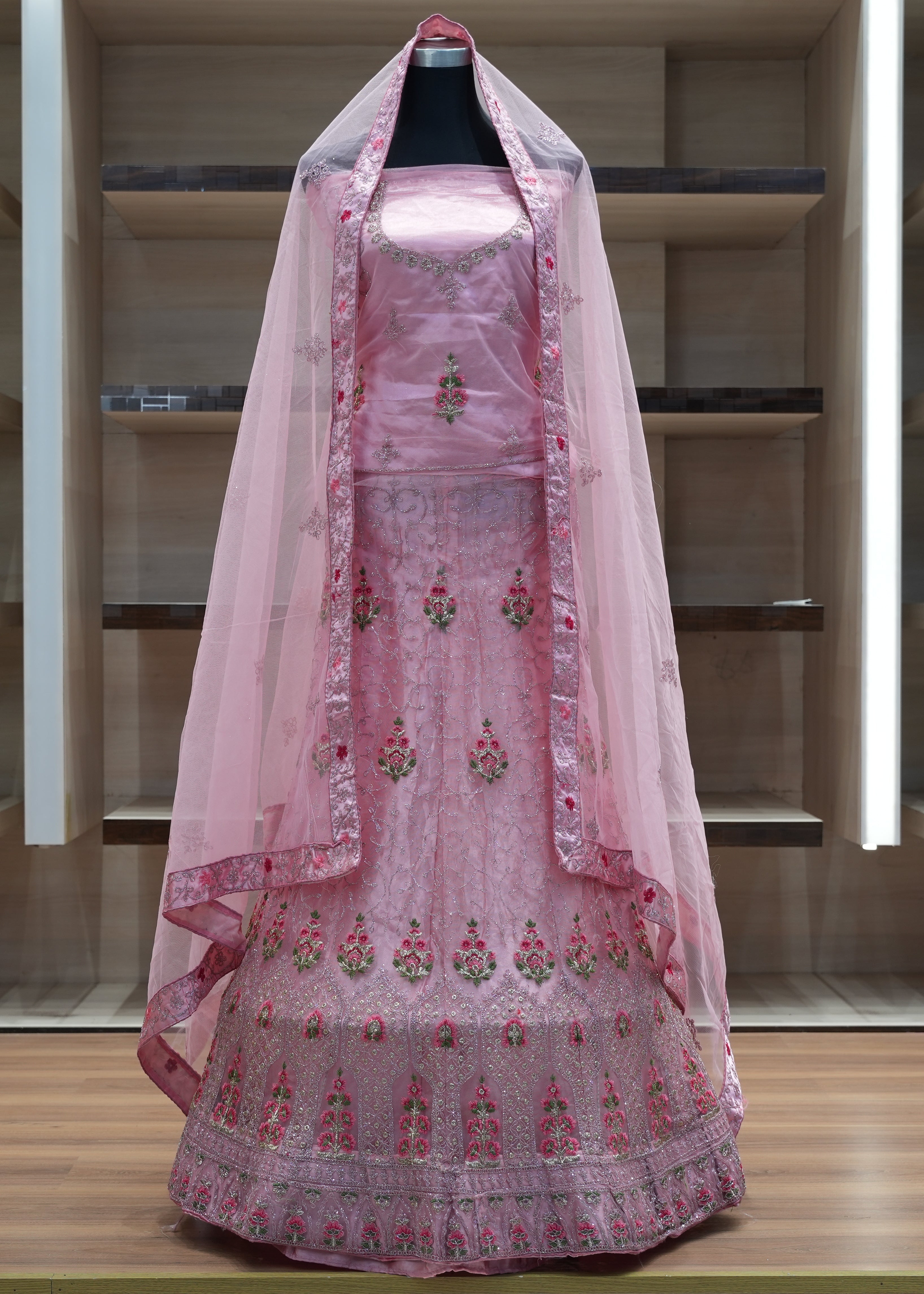 Pink embroidered traditional outfit with a dupatta on a mannequin against a neutral background
