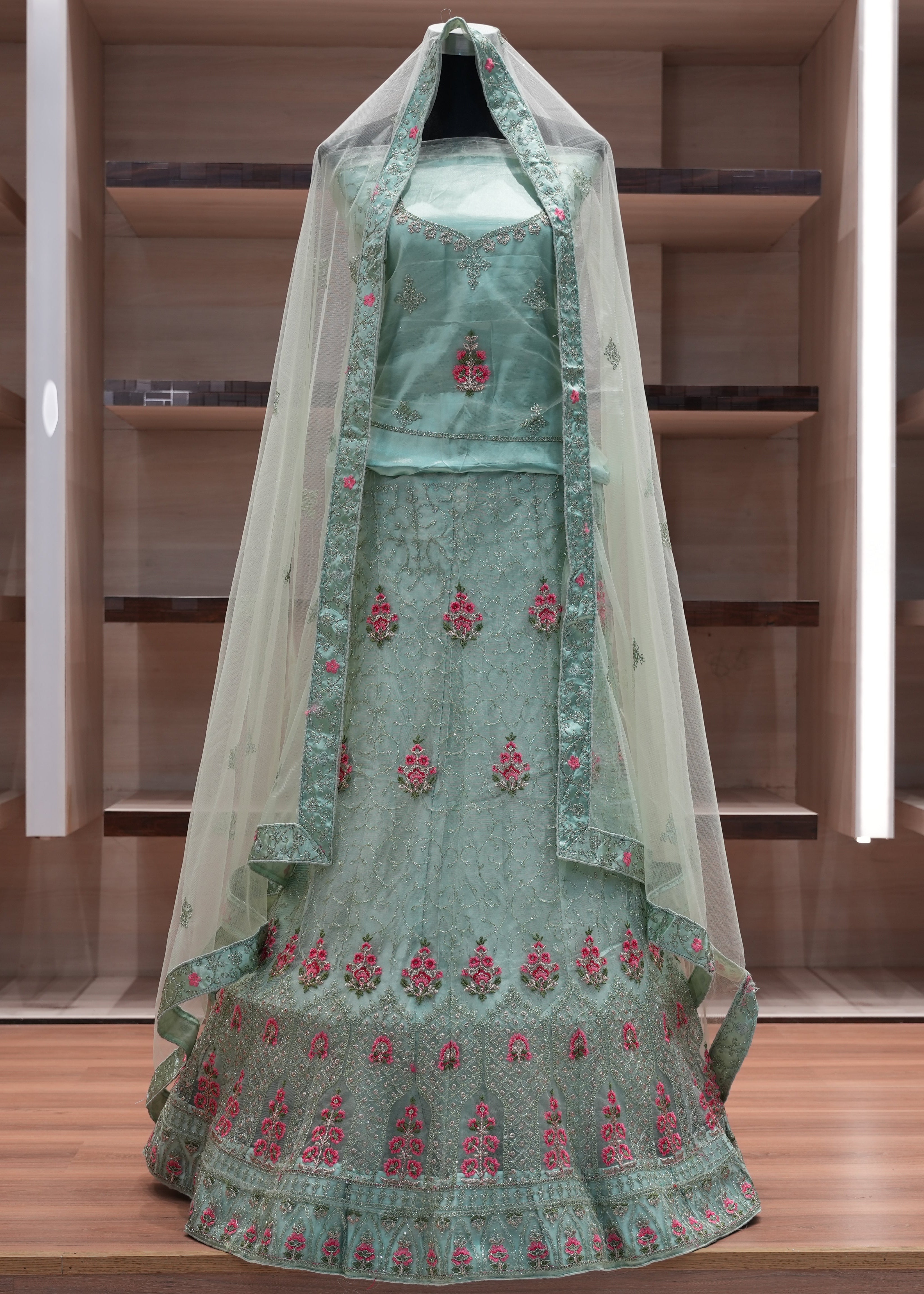 Green embroidered traditional outfit with a veil on a wooden shelf