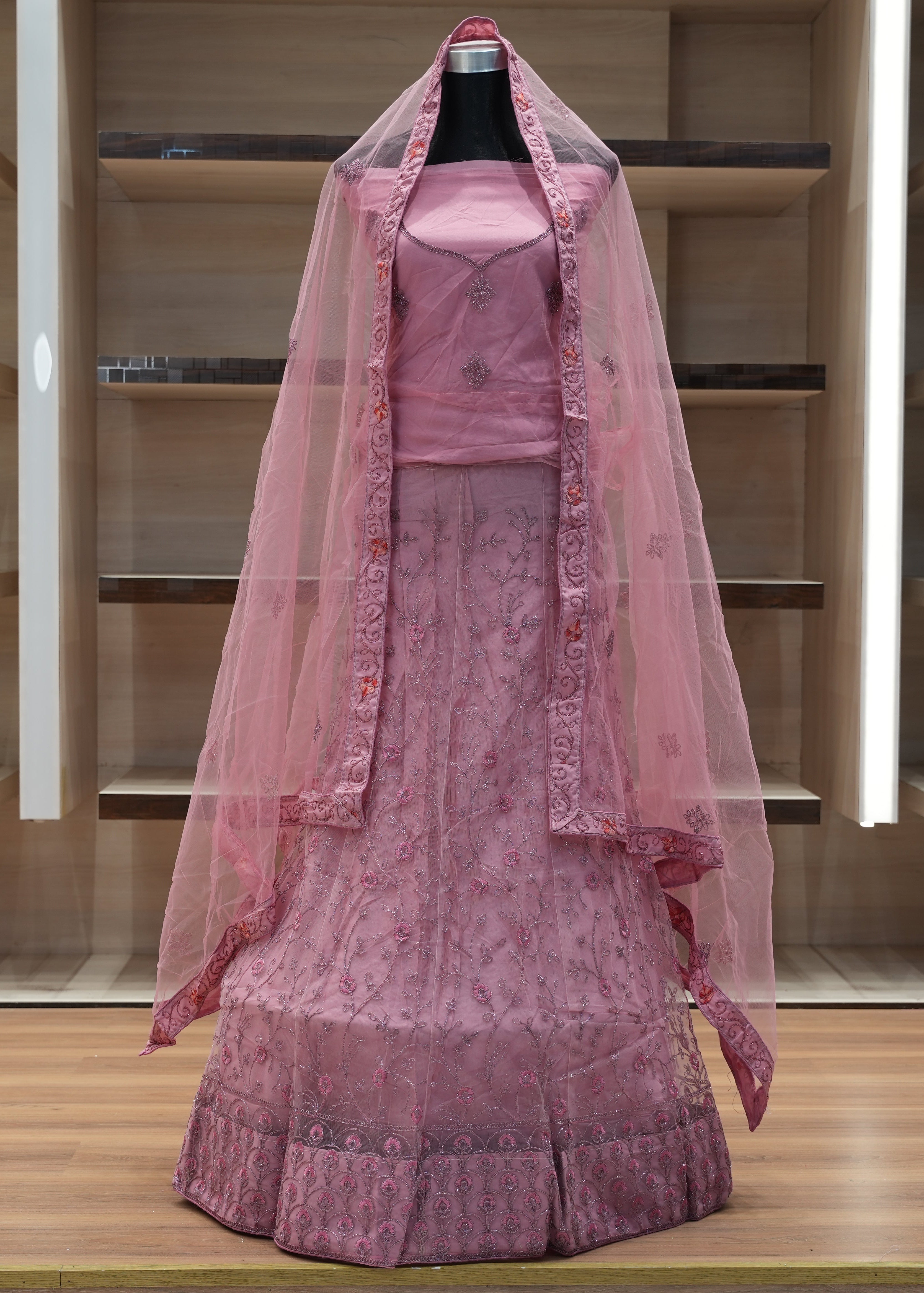 Pink traditional outfit with a dupatta on a mannequin against a neutral background