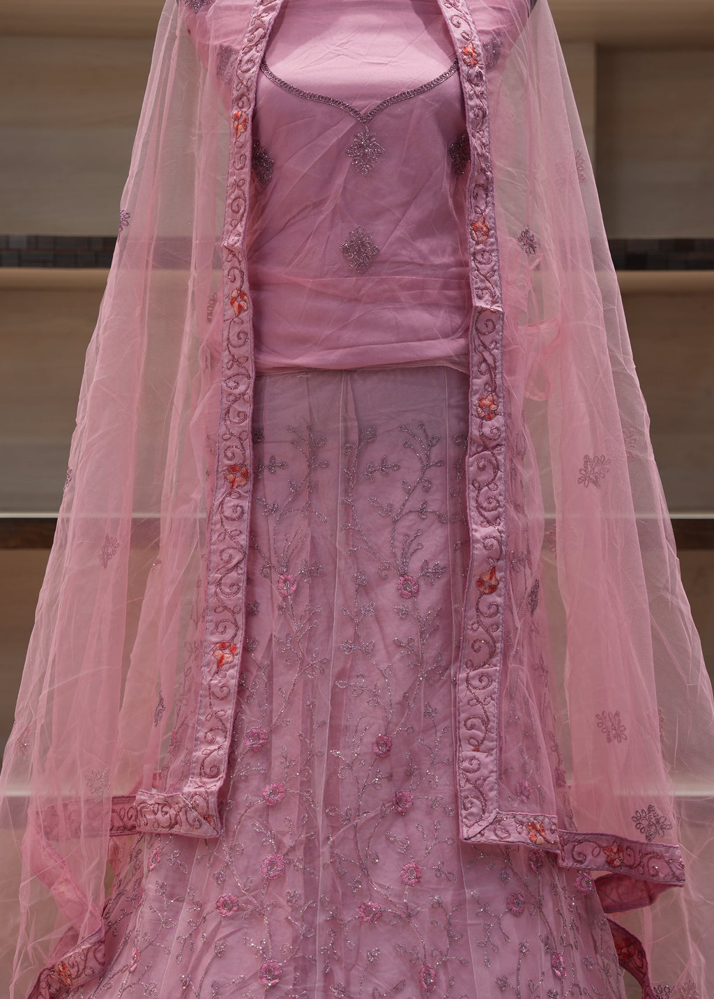 Pink embroidered traditional outfit with a dupatta on a neutral background