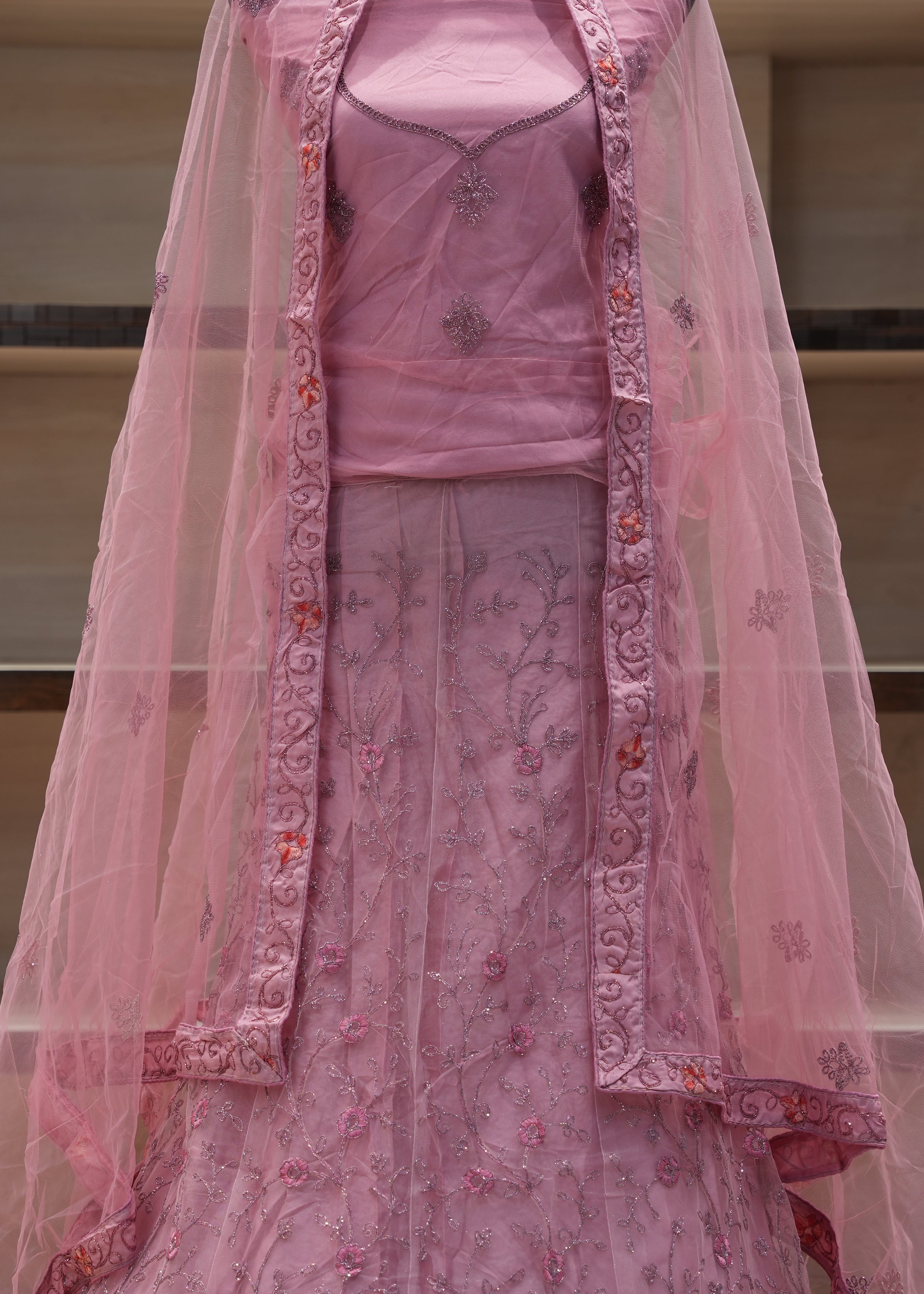 Pink embroidered traditional outfit with a dupatta on a neutral background