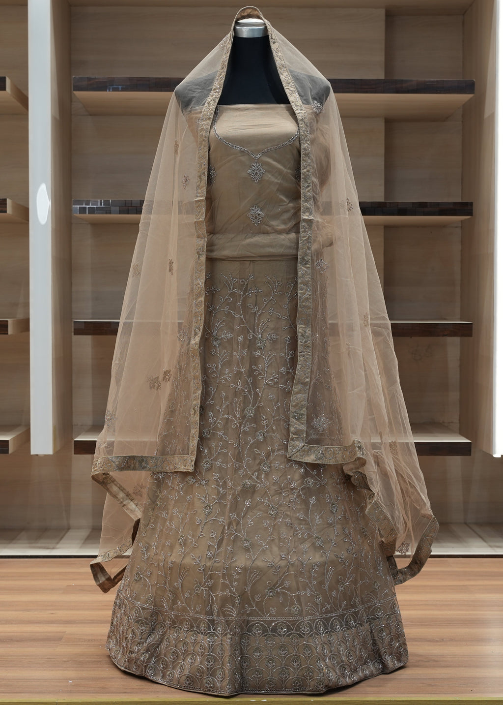 Traditional outfit with a long dress and veil on a mannequin against a wooden background