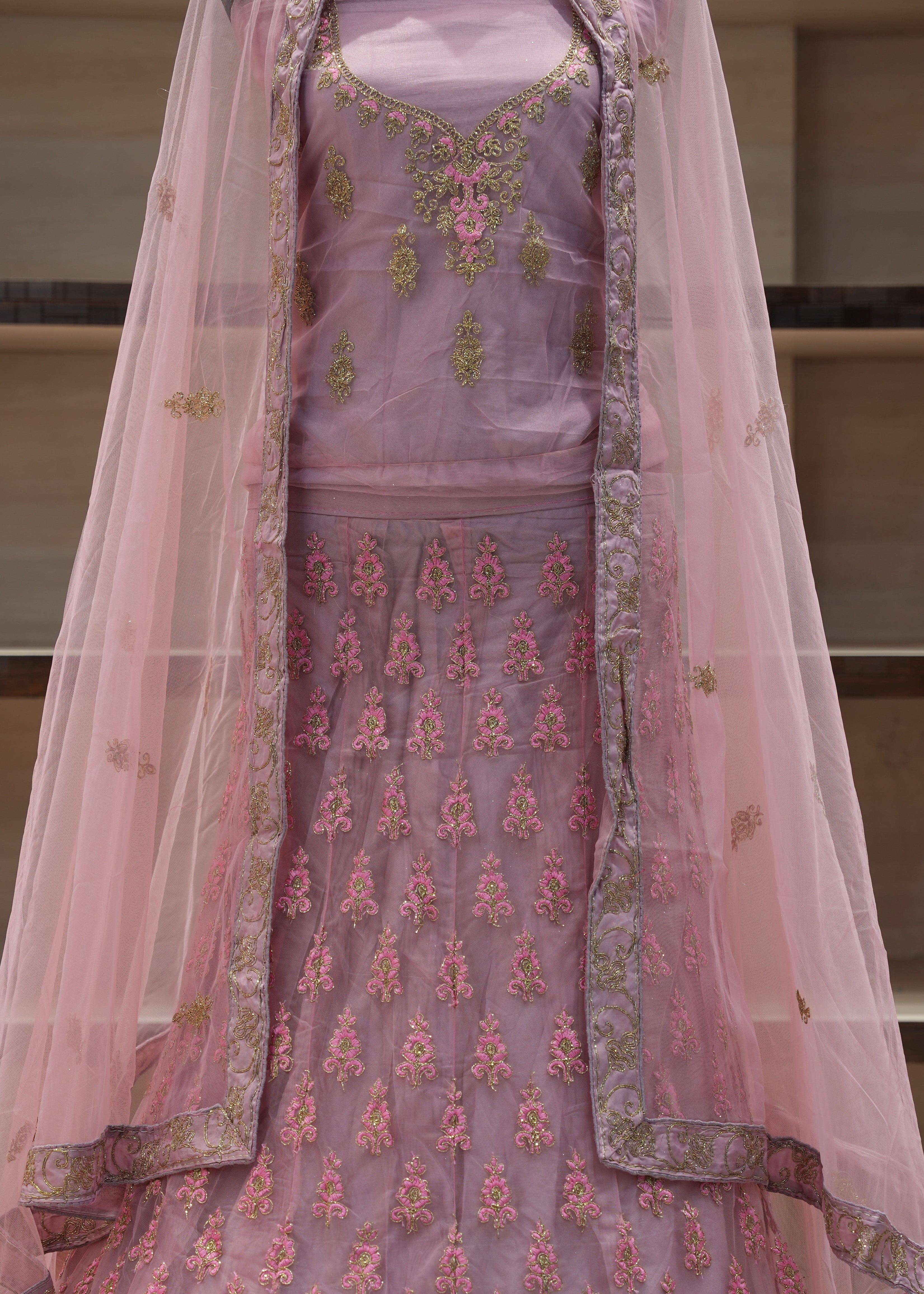 Pink embroidered traditional outfit with a sheer dupatta on a neutral background