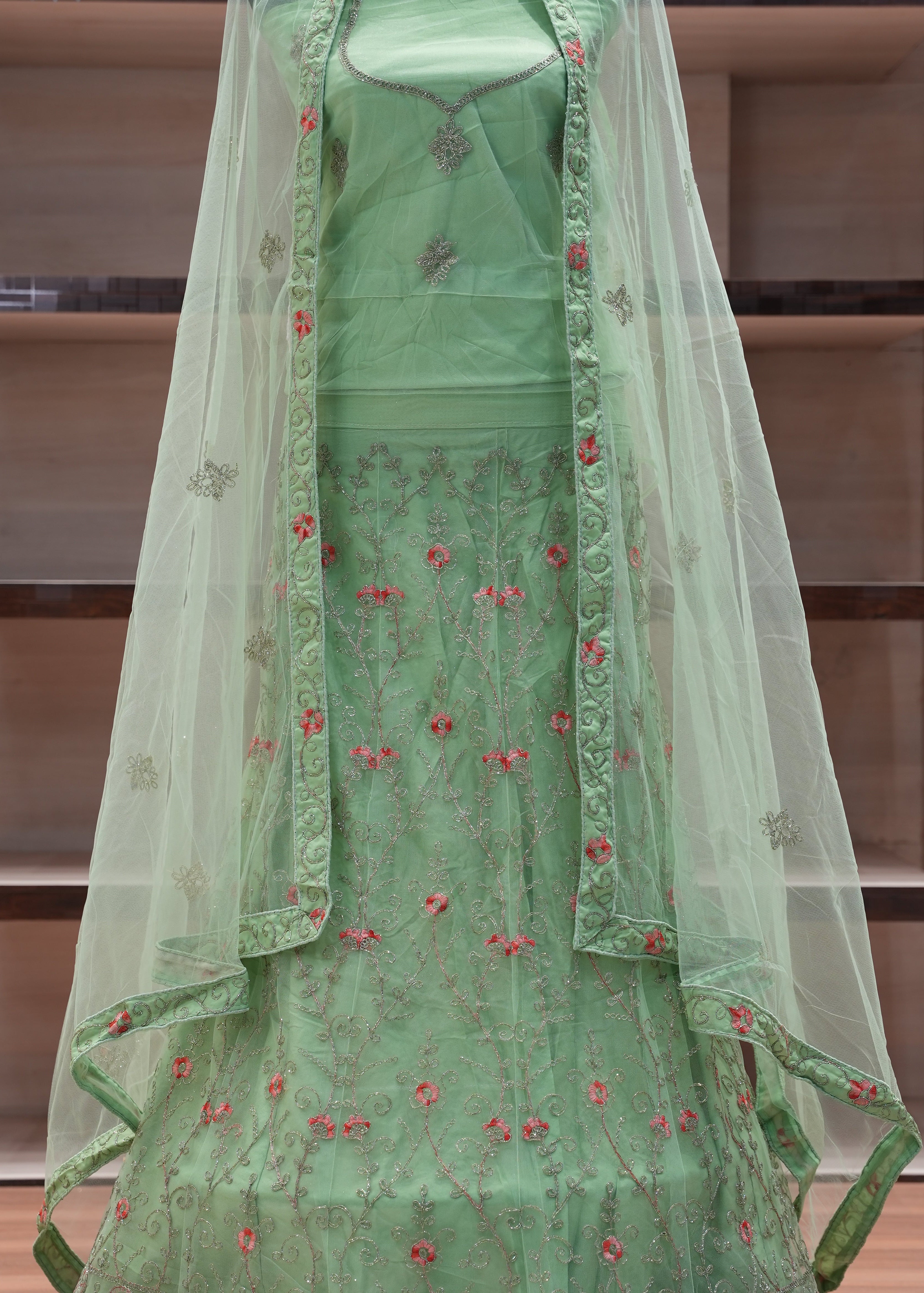 Green embroidered fabric on a wooden shelf