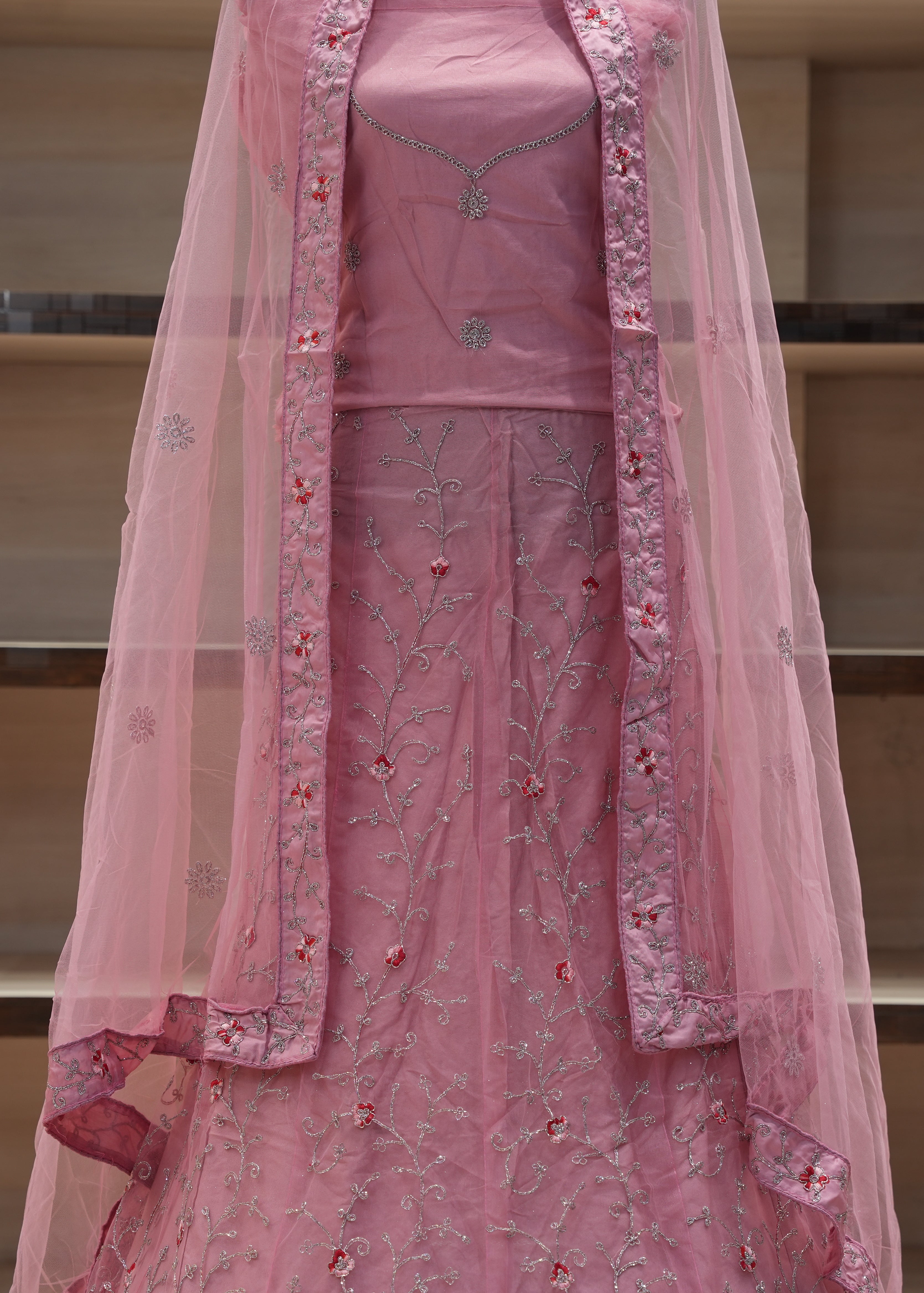 Pink embroidered traditional outfit with a dupatta on a neutral background