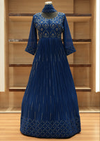 Blue pleated dress with floral patterns on a wooden shelf