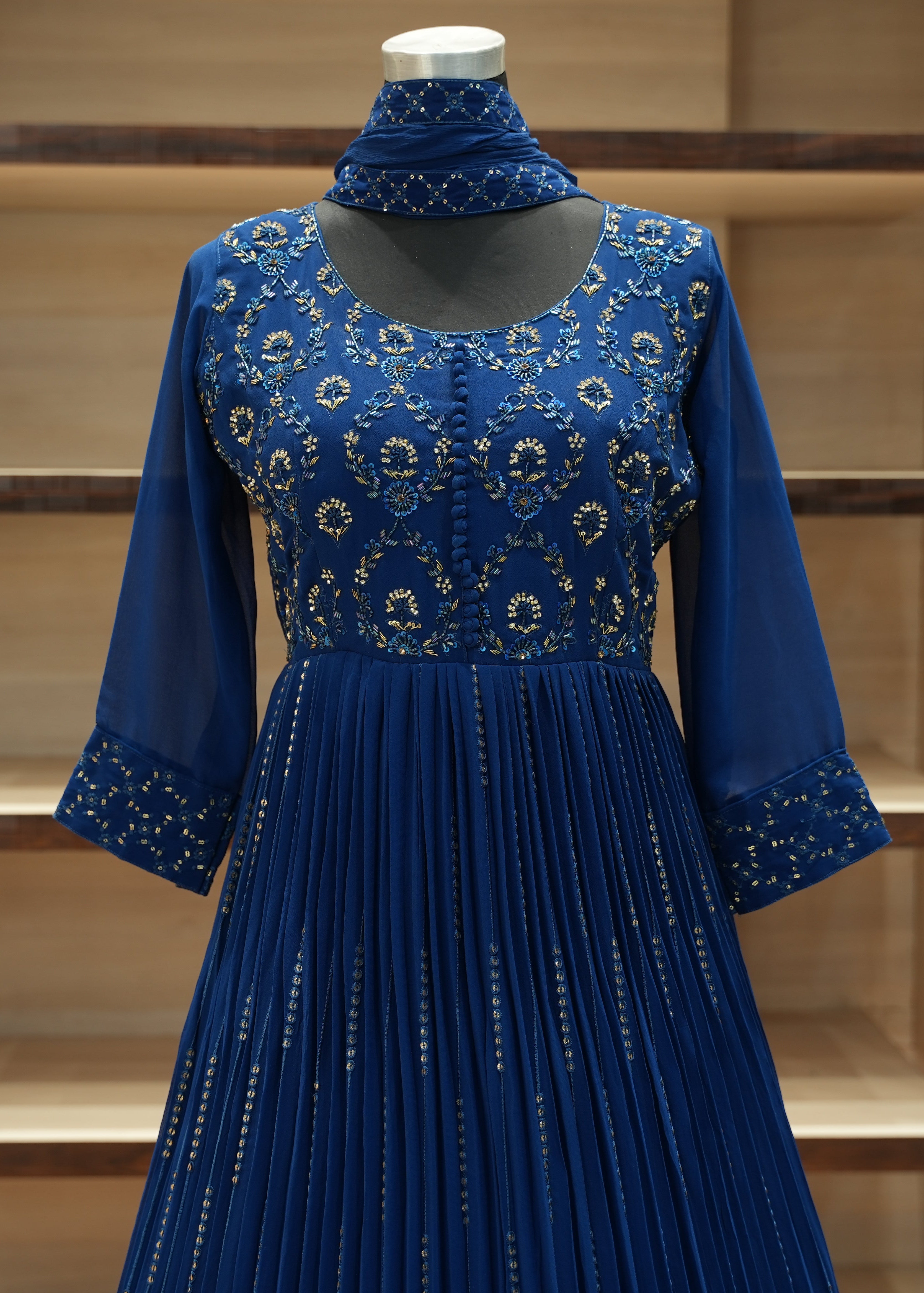 Blue embroidered dress on a mannequin against a neutral background