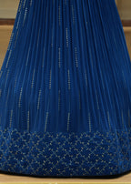 Blue pleated skirt with decorative patterns on a wooden surface