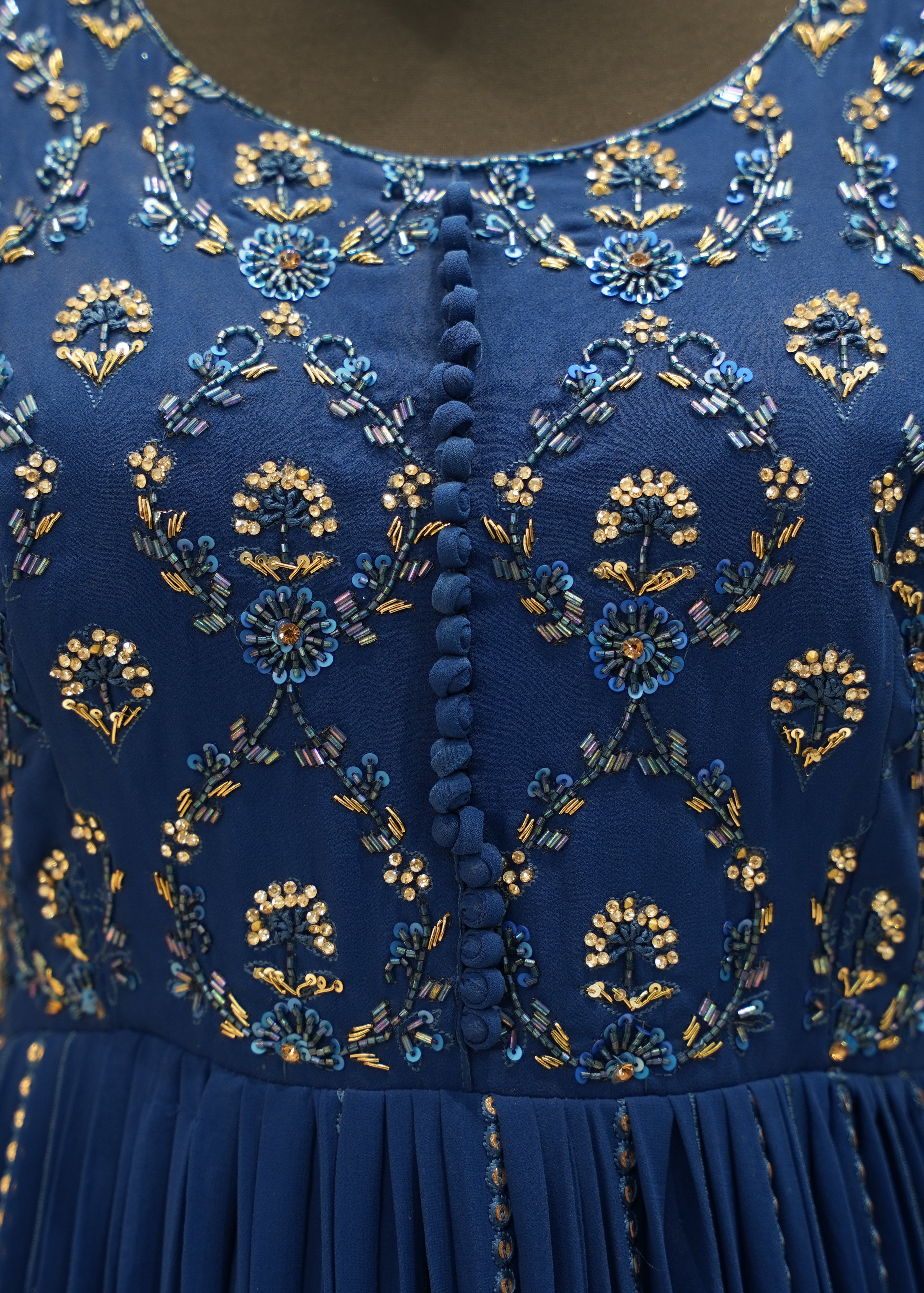 Close-up of a blue dress with intricate gold embroidery