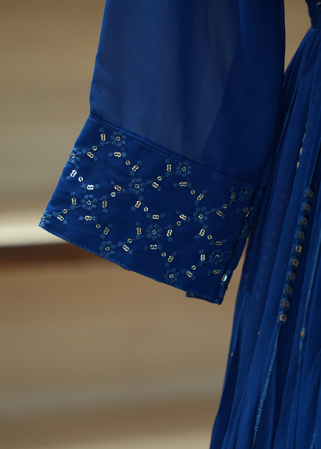 Close-up of a blue dress with intricate detailing on a blurred background