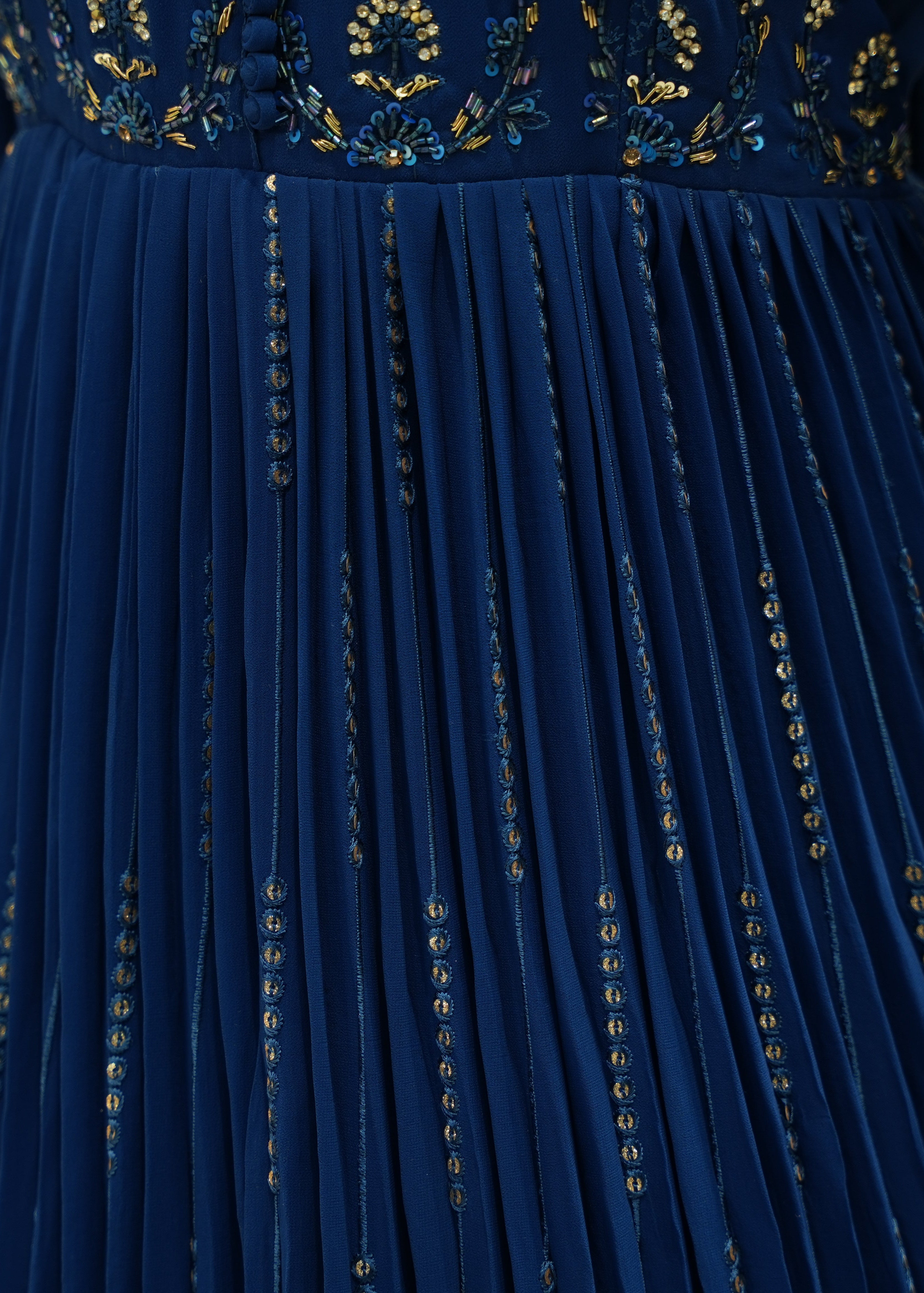 Close-up of a blue dress with gold embroidery details
