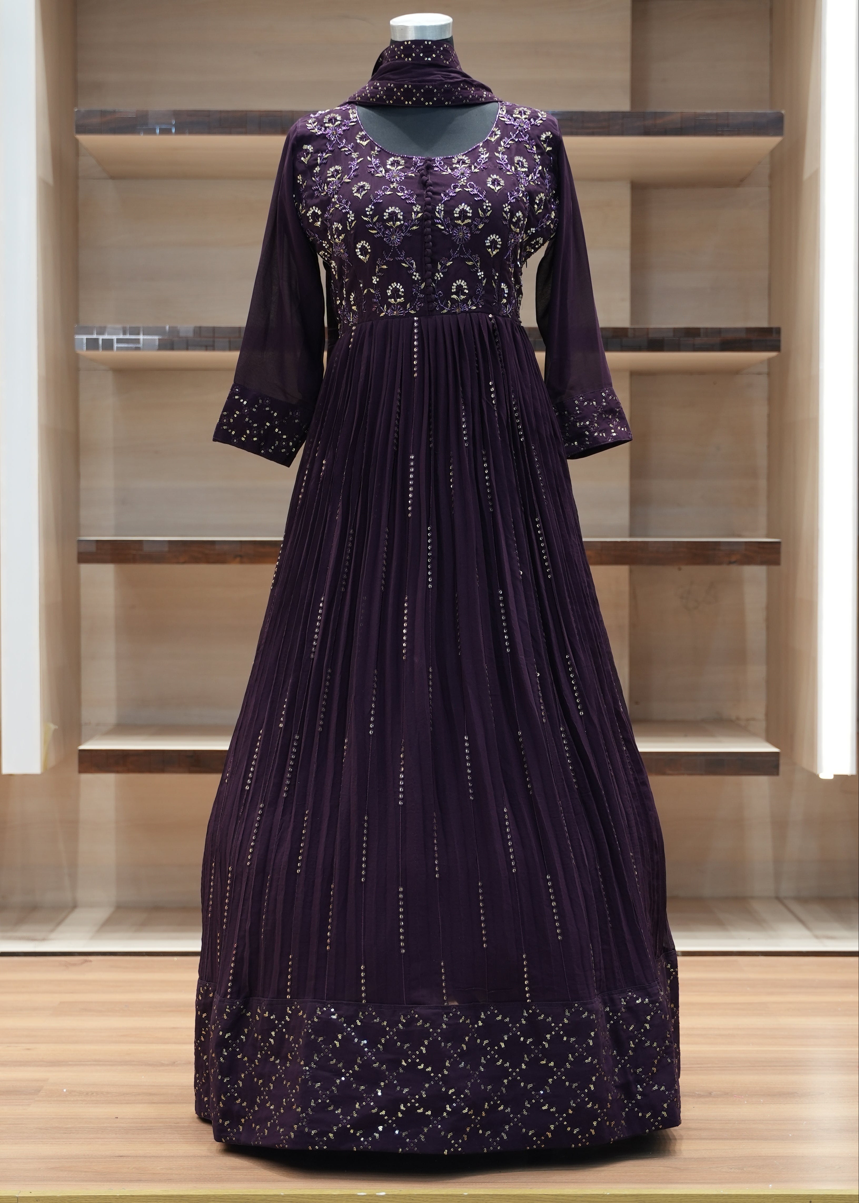 Purple dress with intricate detailing on a wooden shelf