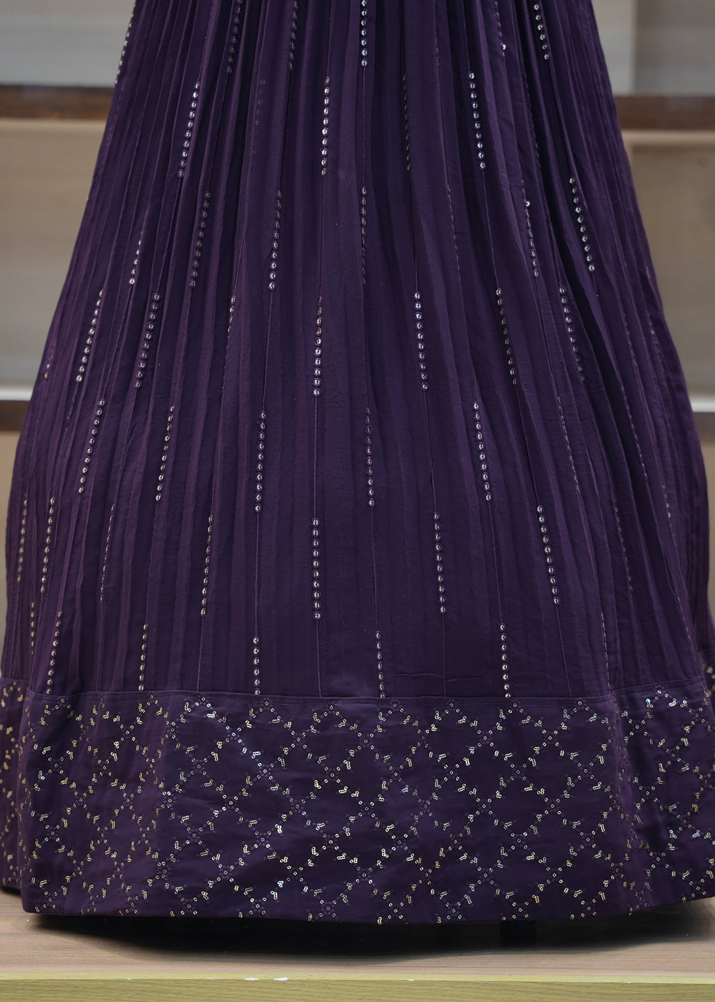 Purple embroidered garment on a wooden surface with a neutral background